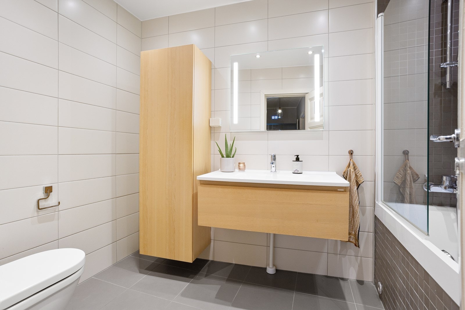 Baderommet har innredning med nedfelt servant, veggmontert toalett og badekar. I tillegg finnes det et høyt skap Det er naturlig ventilering. Galleribilde