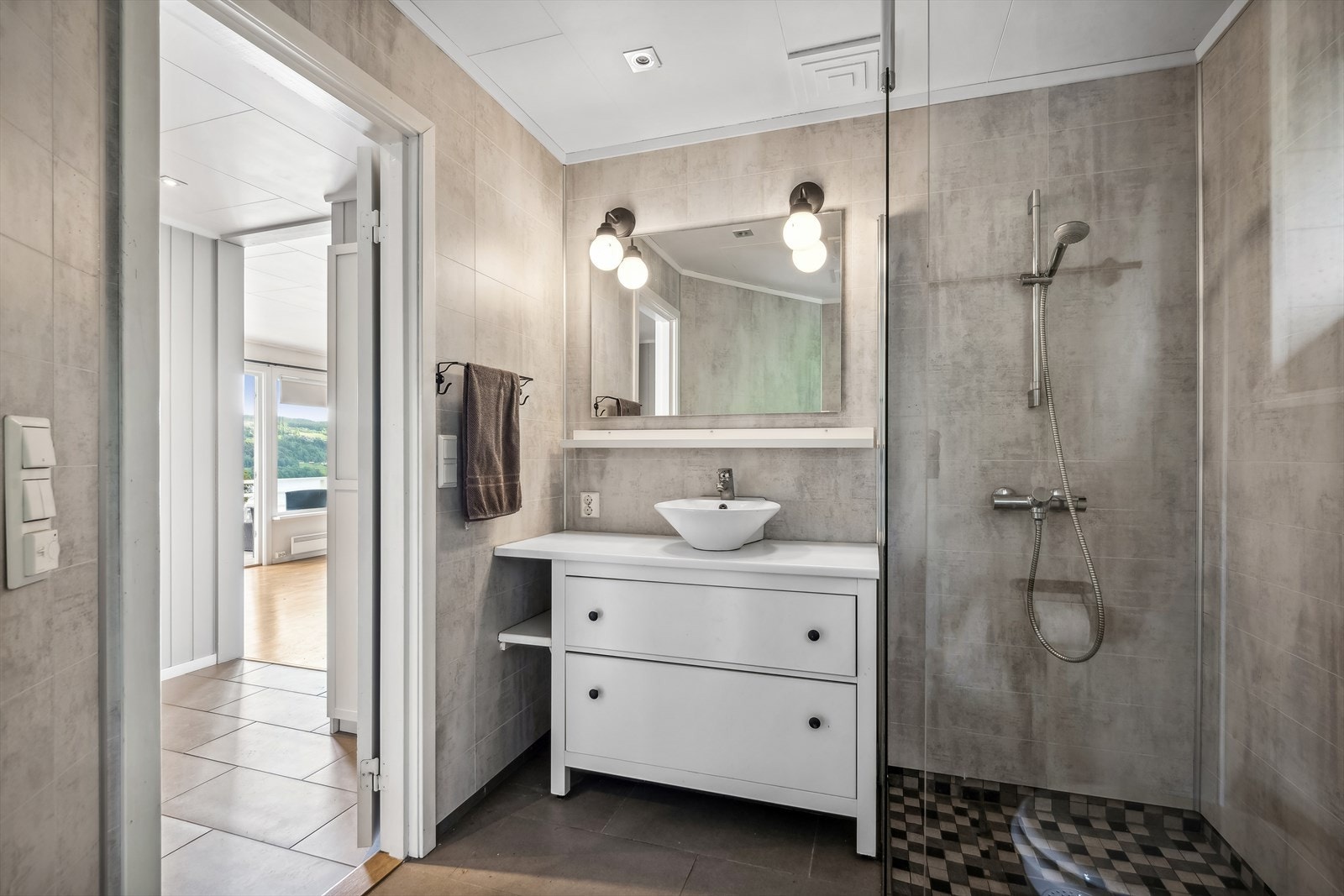 Badet i hovedetasjen ble oppgradert i 2014 og har pene baderomsplater på veggene og fliser på gulvet med varmekabler. Galleribilde