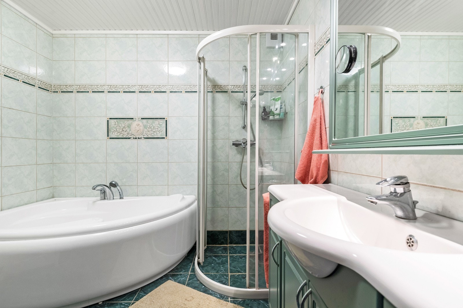 Badet er flislagt, og har både dusjkabinett og badekar. Galleribilde