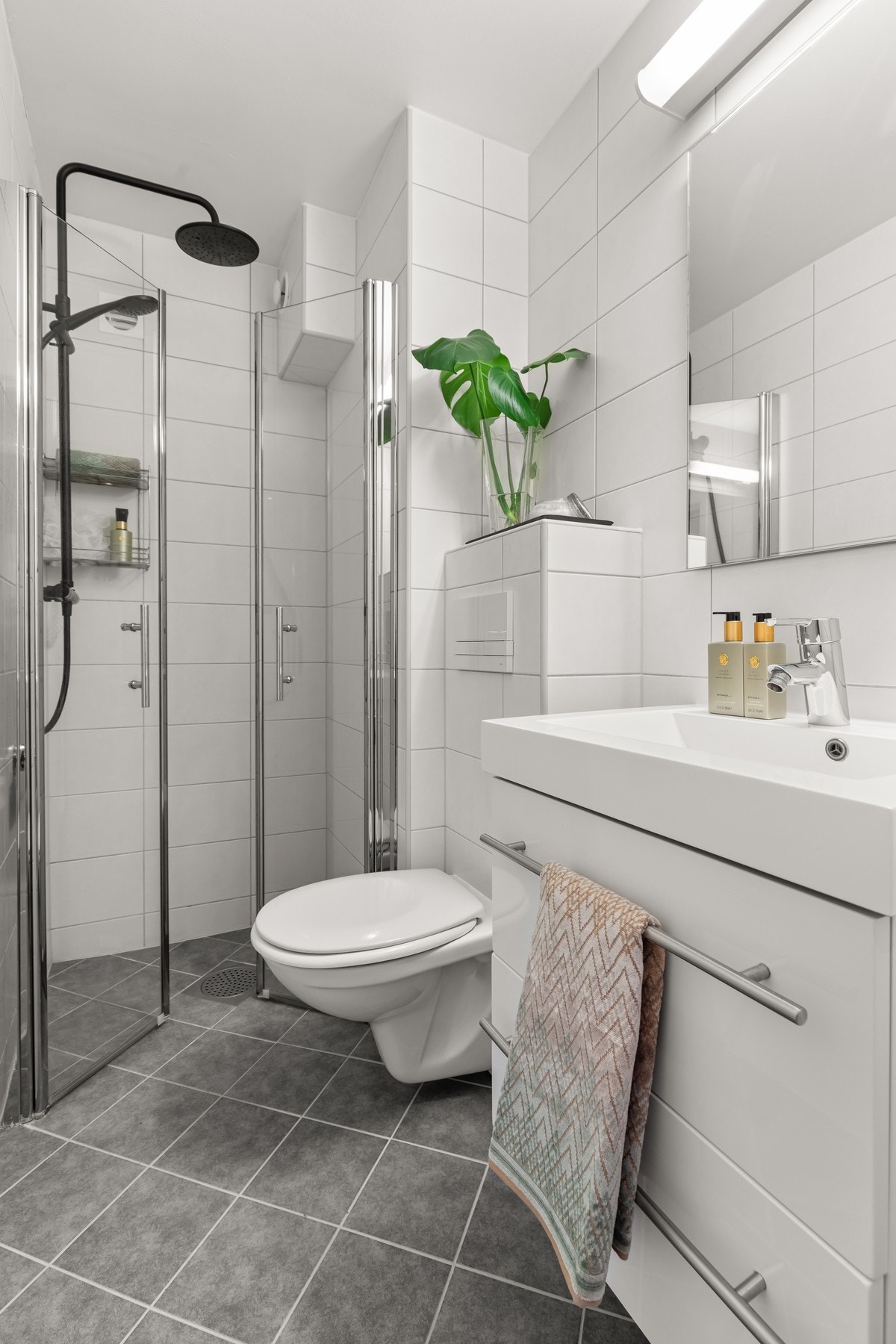 Leiligheten har to flislagte bad og passer perfekt for familier. Her vises badet ved entreen. Galleribilde
