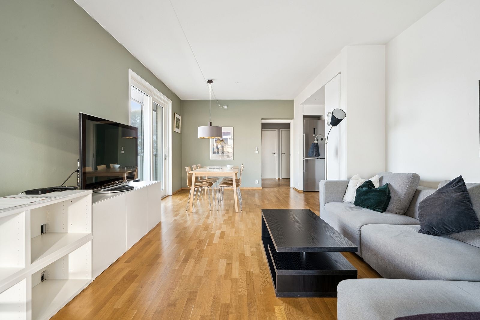 Romslig stue med stor sofa og spisebord Galleribilde