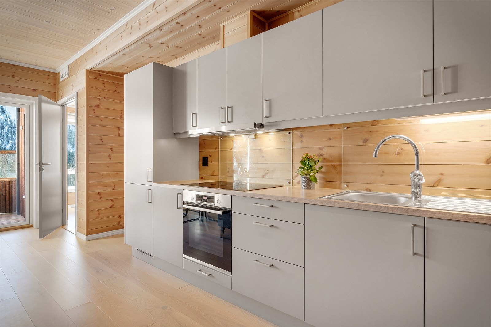 Det er integrerte hvitevarer som platetopp med induksjon, stekeovn, kjøleskap med frysedel og oppvaskmaskin Galleribilde