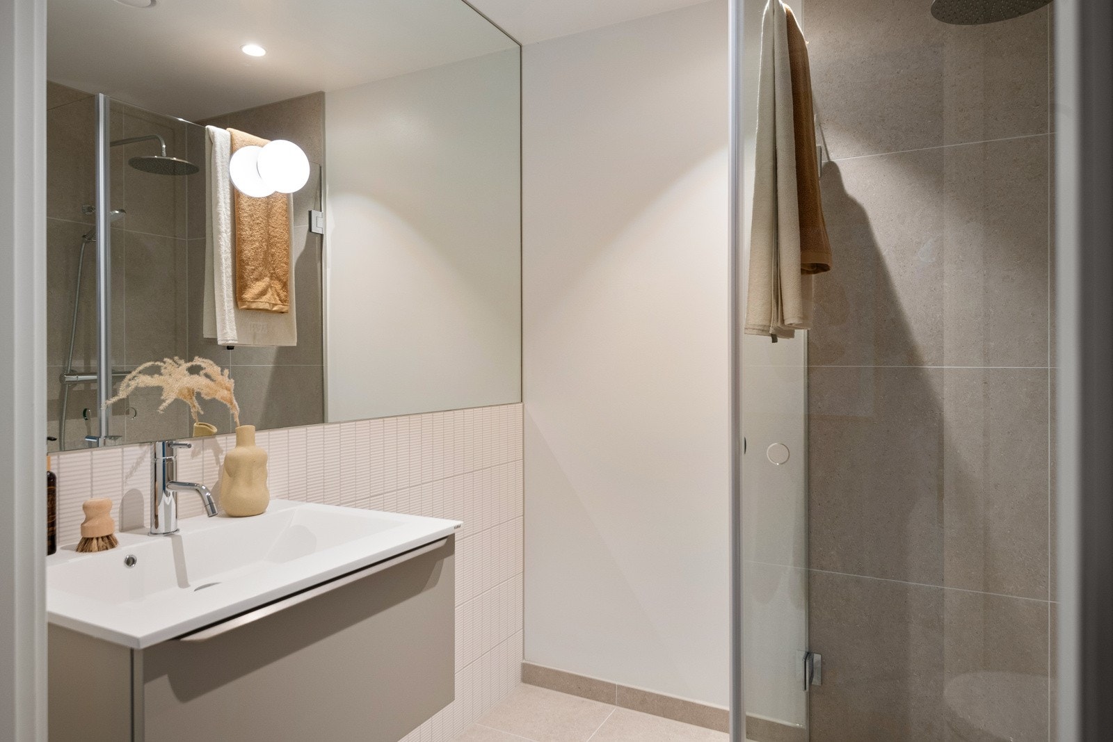 Badeværelset er stedet hvor man kan trekke seg tilbake for å nyte egentid og finne roen i behagelige og vakre omgivelser. Interiørarkitektene har laget en helhetlig design med vegghengt servant med undermontert skuff fra HTH. Galleribilde