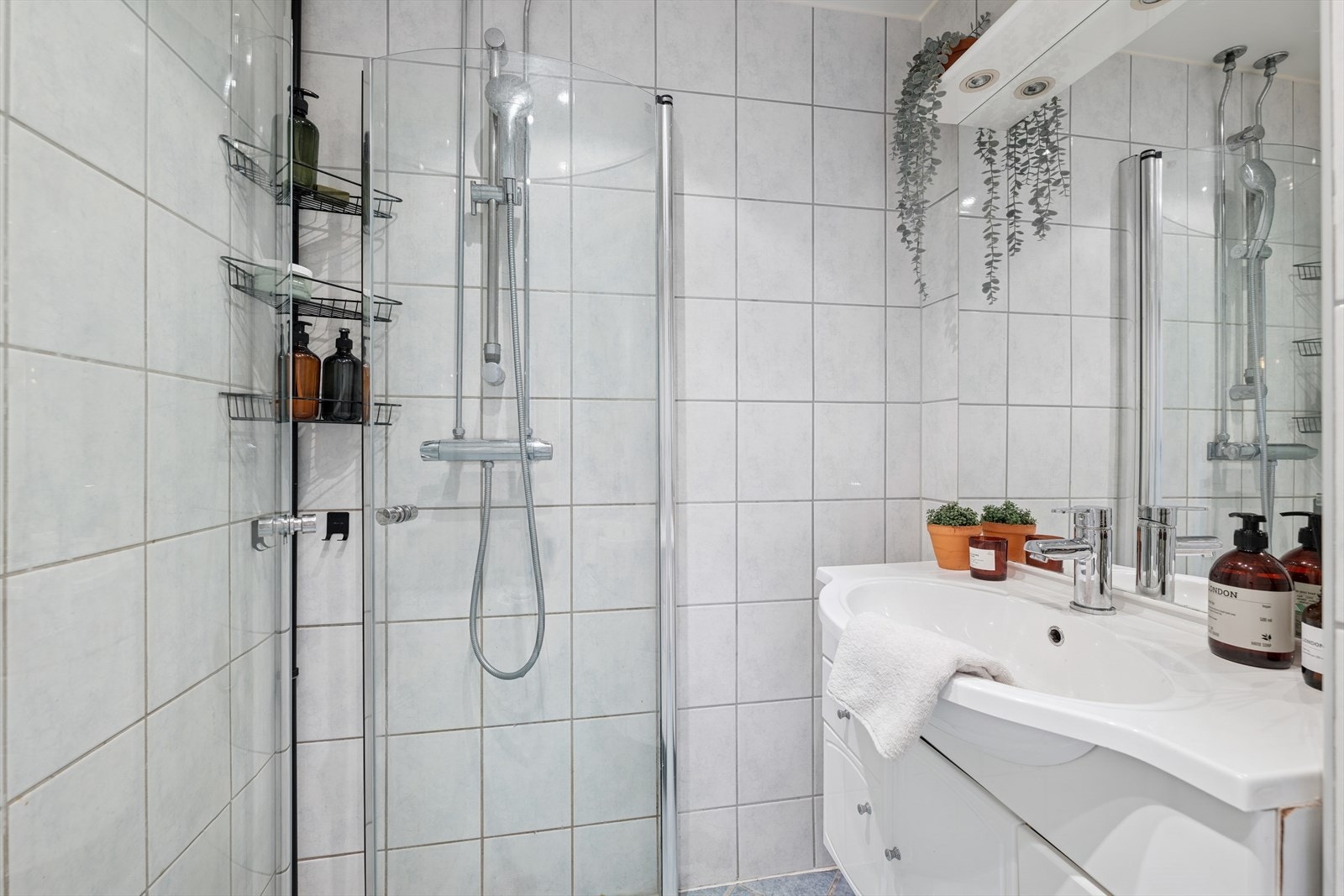 Badet har heldekkende servant og skapseksjon med oppbevaringsmuligheter Galleribilde