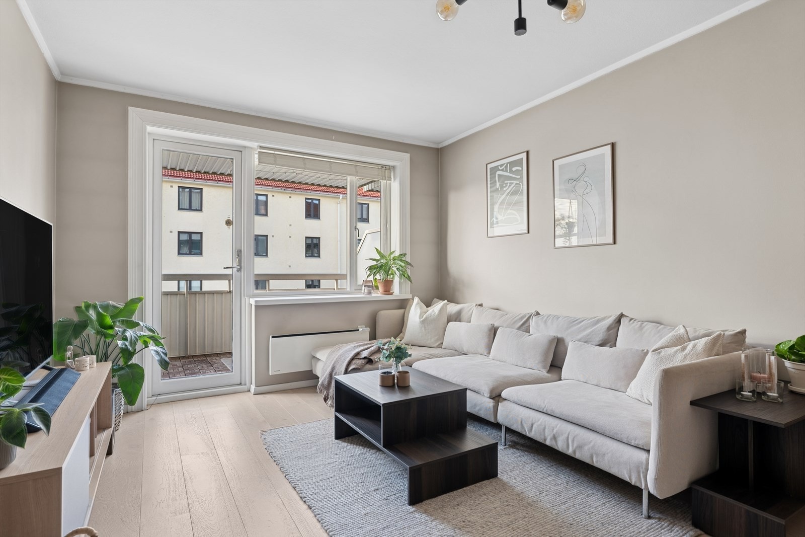 Stuen er lys og luftig takket være stuens store vindusflater Galleribilde