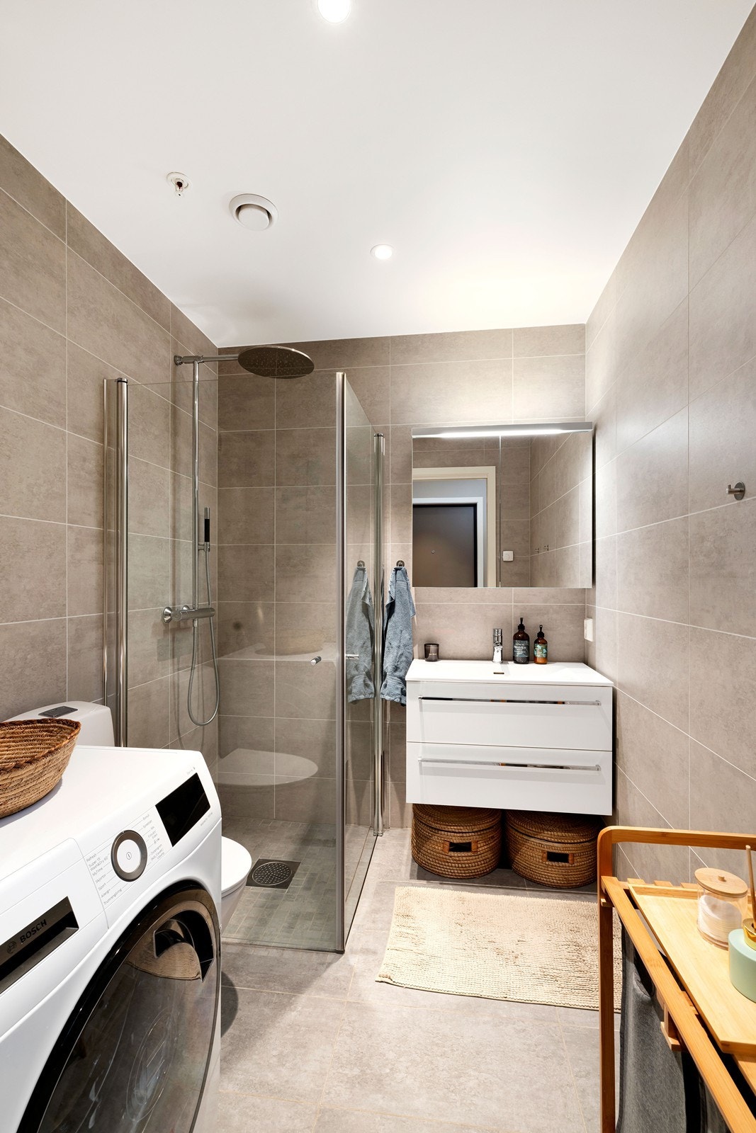 Bad inneholder dusjhjørne, servant med underskuffer, wc og opplegg for vaskemaskin Galleribilde