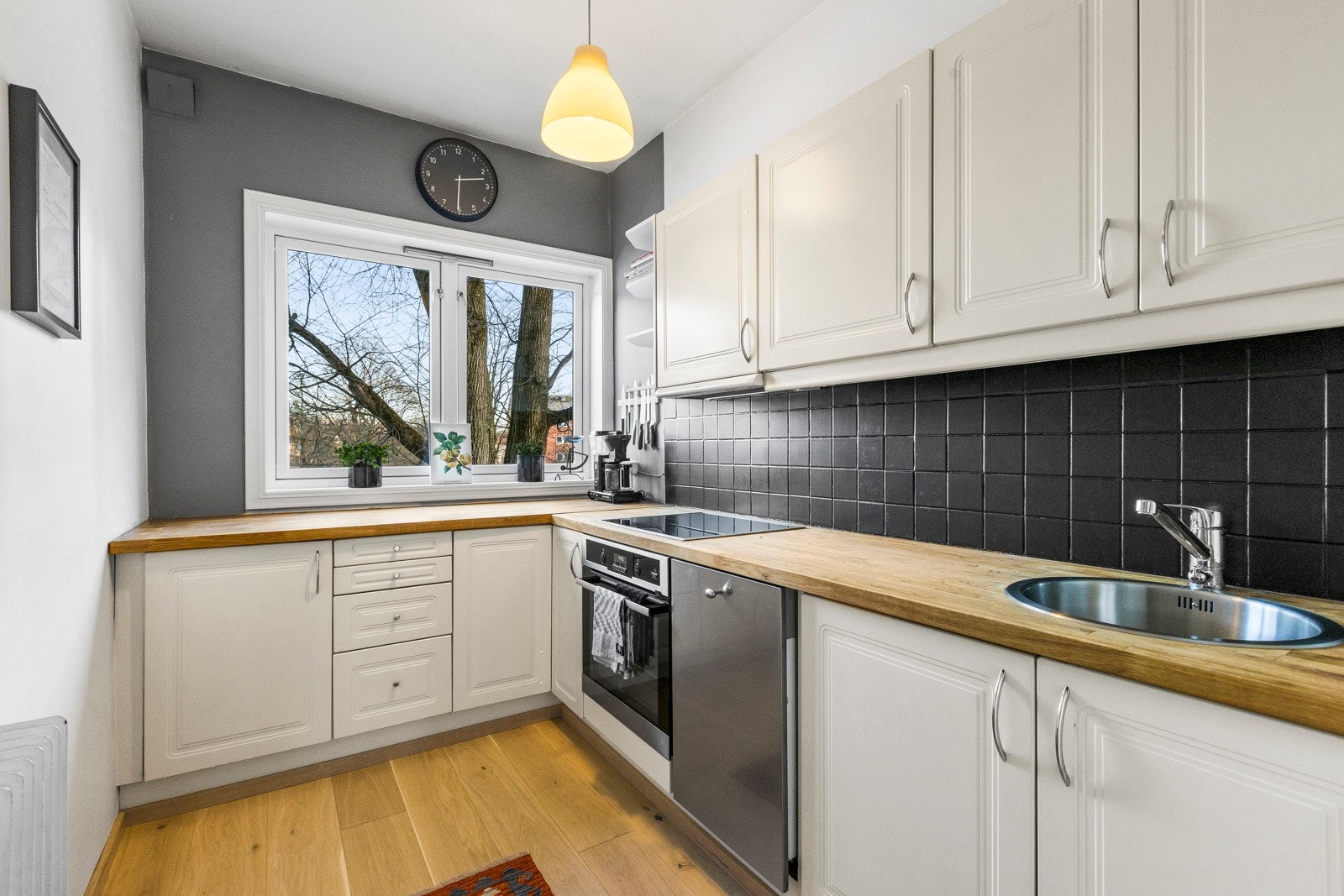 Separat kjøkken med innredning med profilerte fronter og benkeplate av tre. Galleribilde