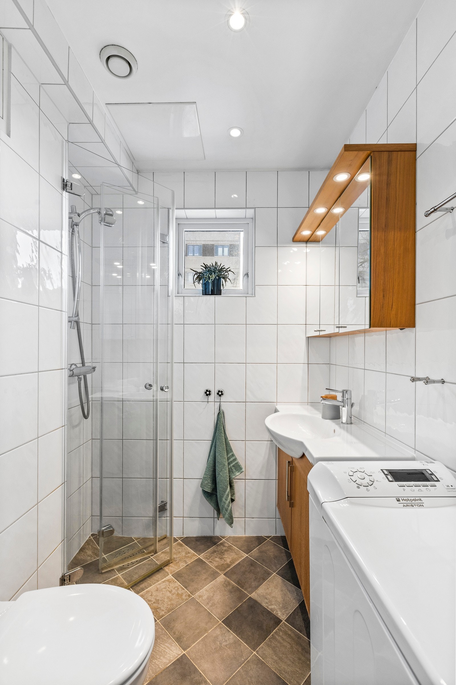 Delikat flislagt baderom med opplegg for vaskemaskin. Galleribilde