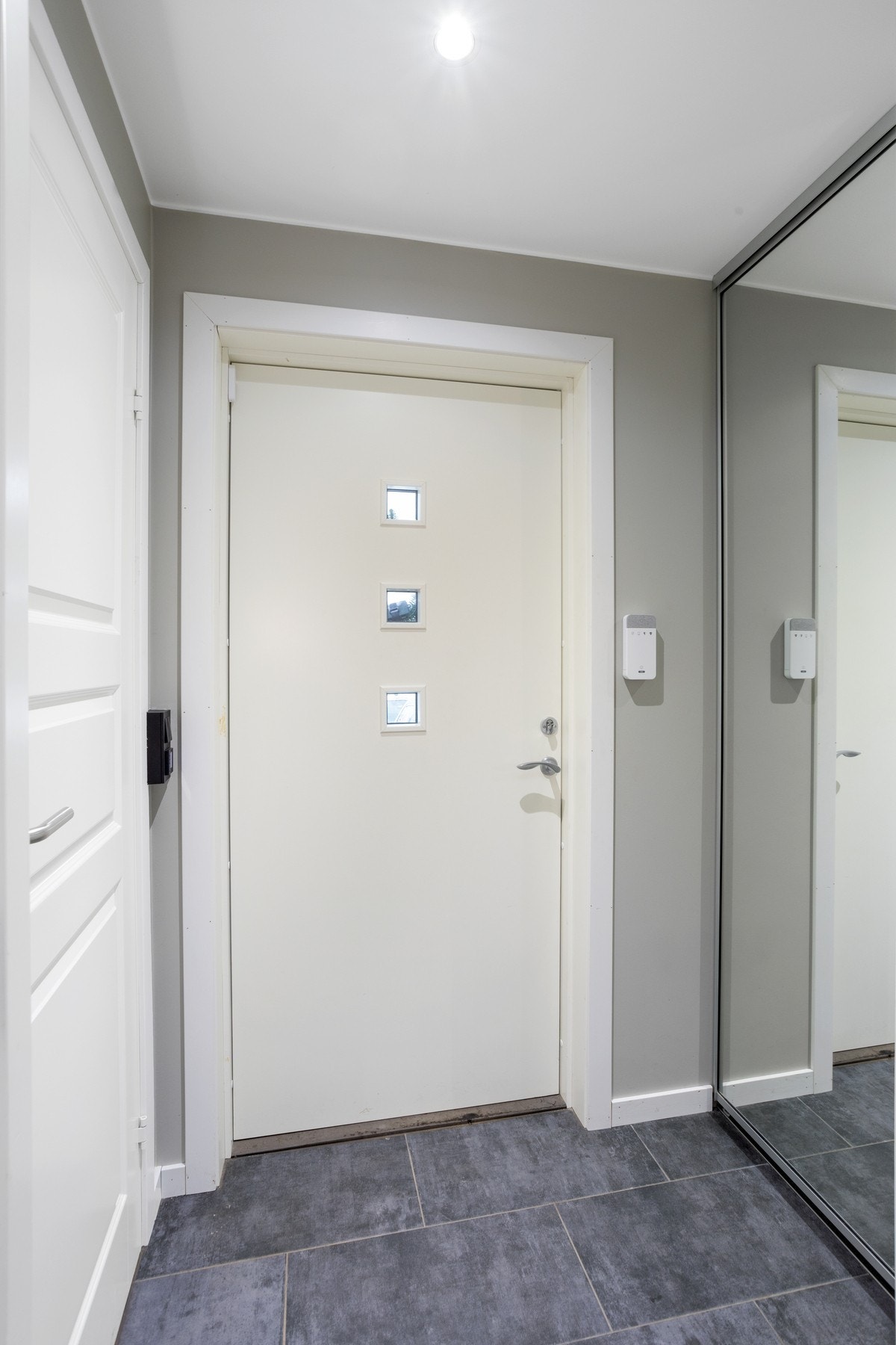 Lys og fin entré med flislagt gulv, downlights og skyvedørsgarderobe. Galleribilde