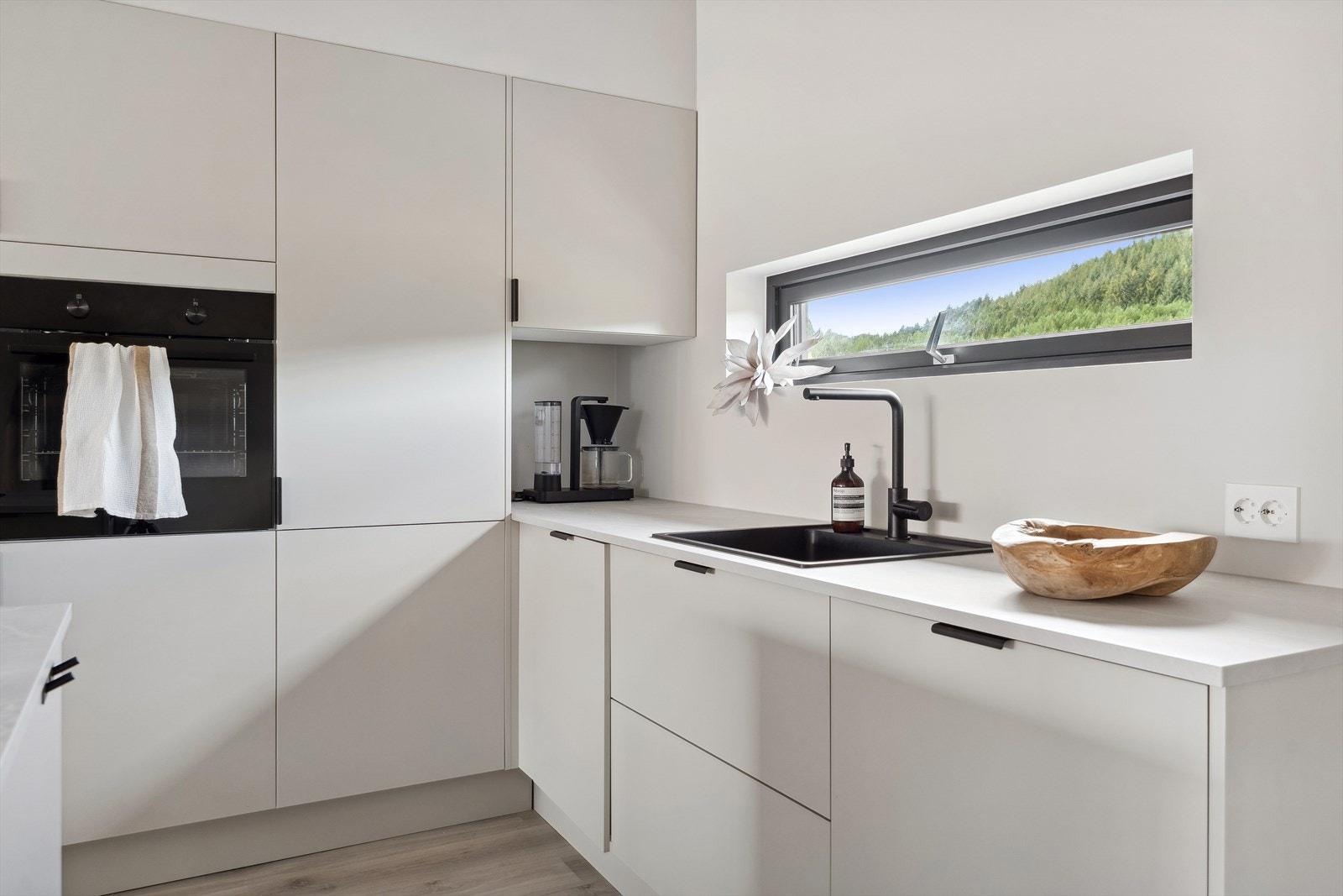 Praktisk smalt vindu på kjøkkenet der du kan følge med på ungane som leiker utanfor mens du lager mat Galleribilde