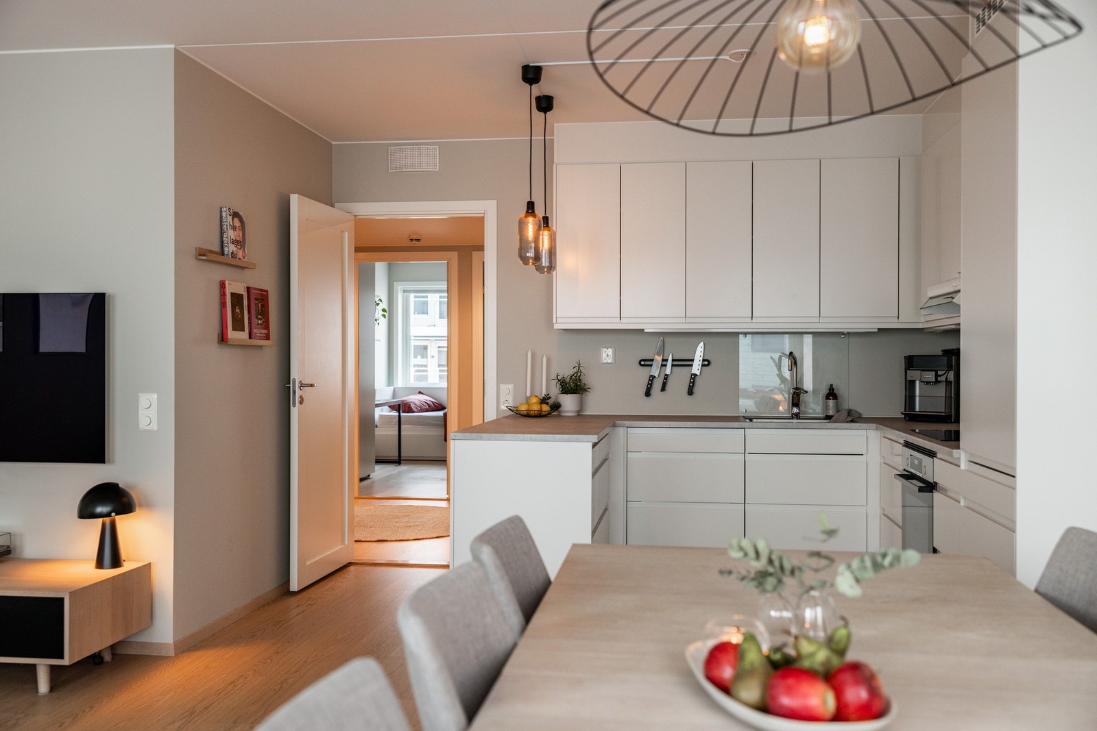 Lys og tidsriktig Sigdal kjøkkeninnredning med integrert kjøl/fryseskap, oppvaskmaskin, stekeovn og induksjon platetopp. Galleribilde