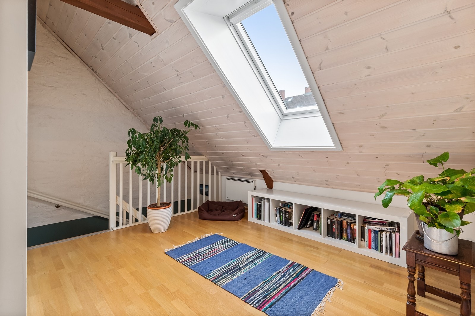 Skråtak med delvis veldig god takhøyde og takvinduer gir en åpen og lys følelse i 2. plan Galleribilde