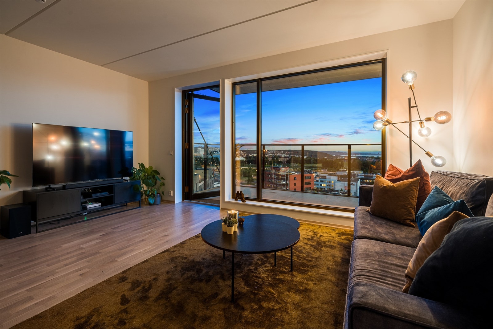 Innbydende stue i åpen løsning med kjøkkenet. Et sosialt og godt rom med plass til større spisebord i tillegg til naturlig stuemøblement som en sofa med tilhørende salongbord. Galleribilde
