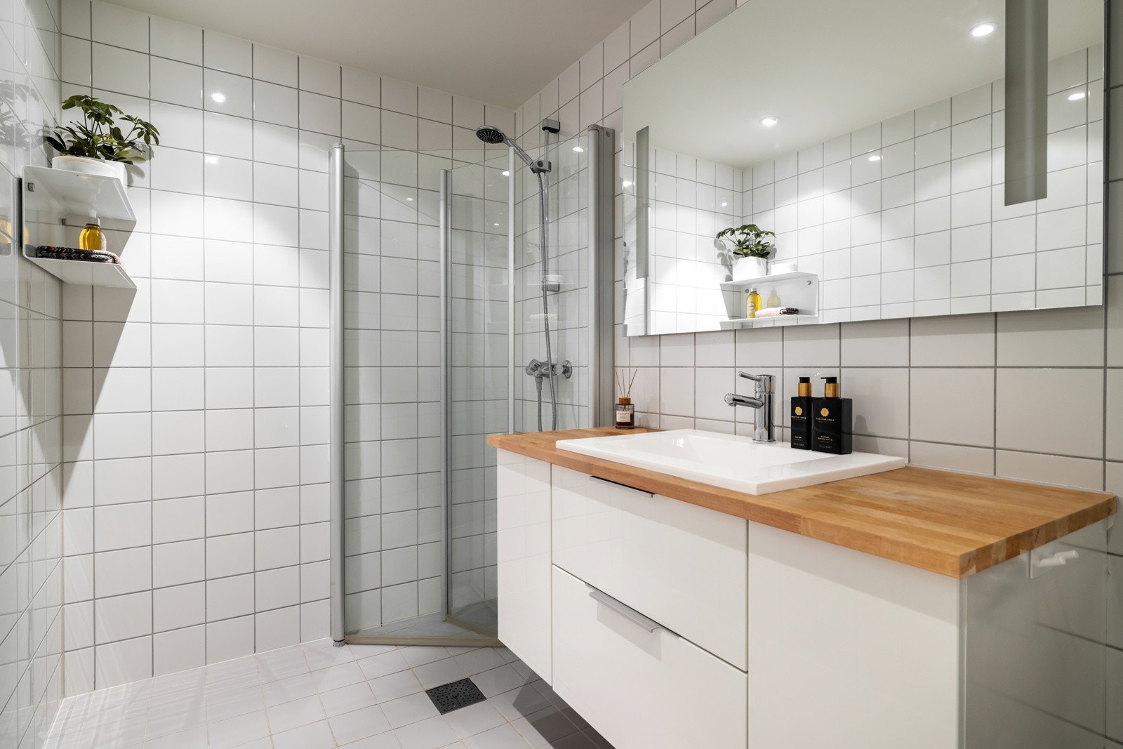 Badet er flislagt med vannbåren varme og har bra med lagring i servantinnredningen i to skuffe og to skap Galleribilde