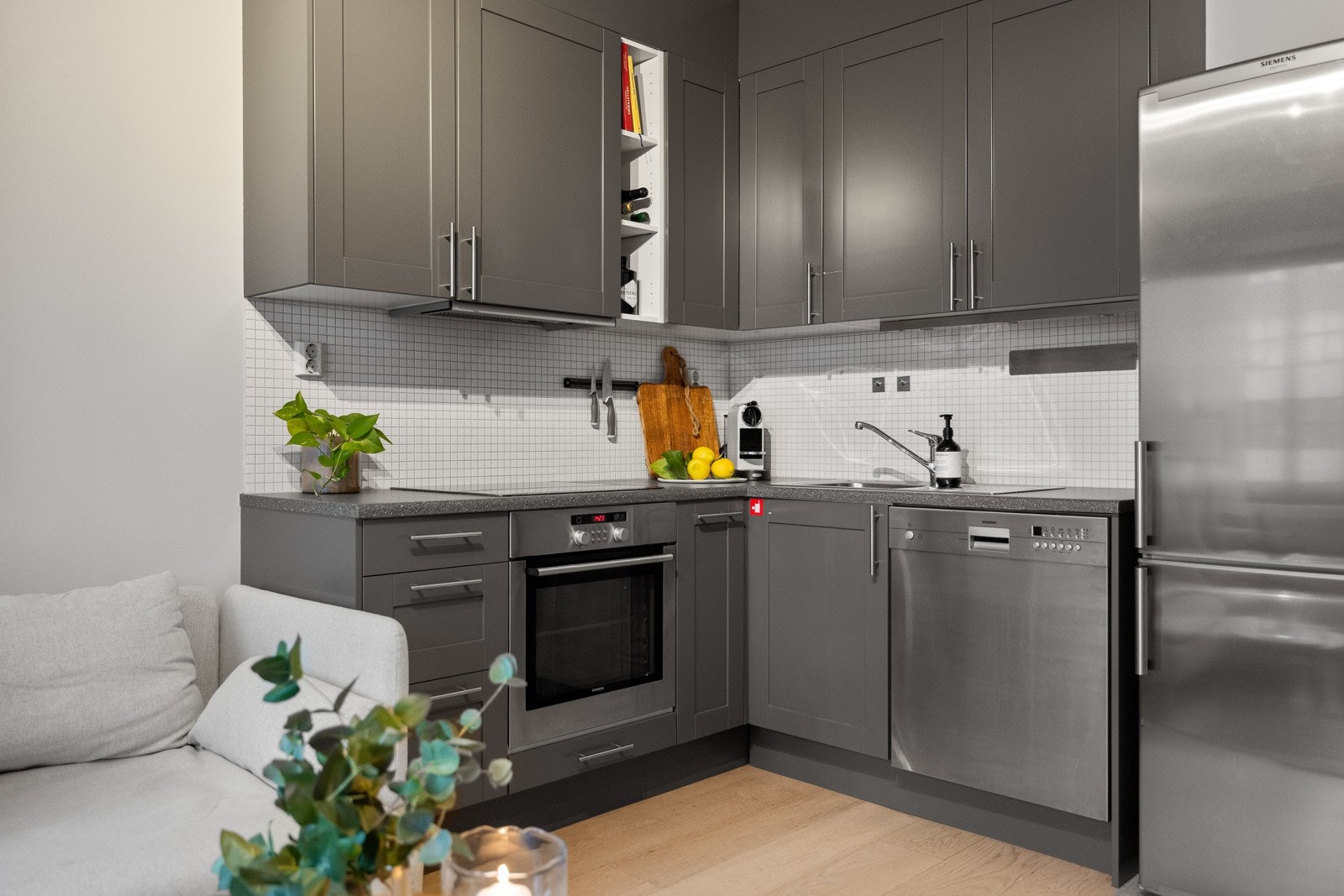 Stilren kjøkkeninnredning med integrert platetopp, stekeovn og oppvaskmaskin. Galleribilde