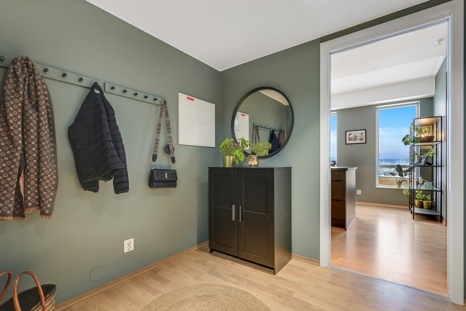 Velkommen inn i en entré med grønne vegger og lyst tregulv. Galleribilde