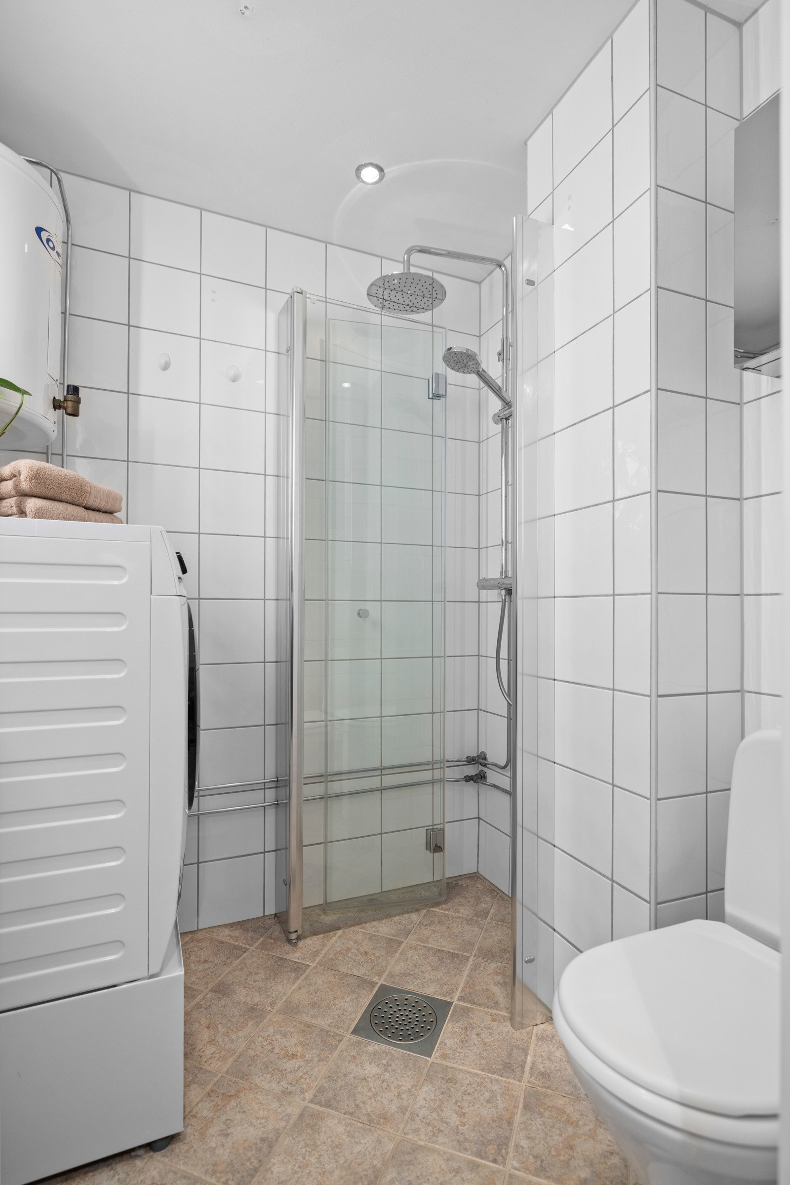 Glassdører i dusjnisjen kan praktisk foldes inn for å skape mer plass. Galleribilde