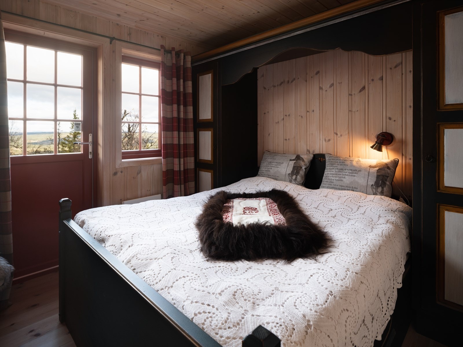 Hovedsoverom innredet med plassbygde skap og seng i hyttestil Galleribilde