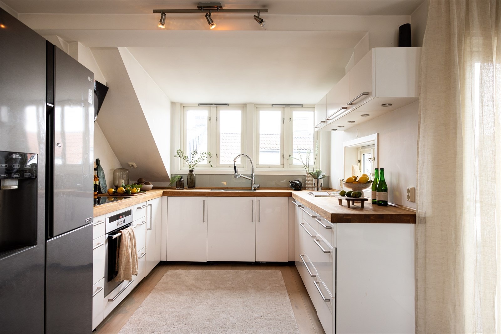 - Kjøkkeninnredning med glatte fronter og heltre benkeplate med nedfelt vask- og skyllekum - Galleribilde