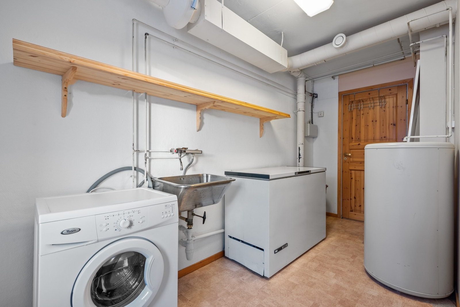 Vaskerom utstyrt med bereder, skyllekum og opplegg for vaskemaskin. Galleribilde