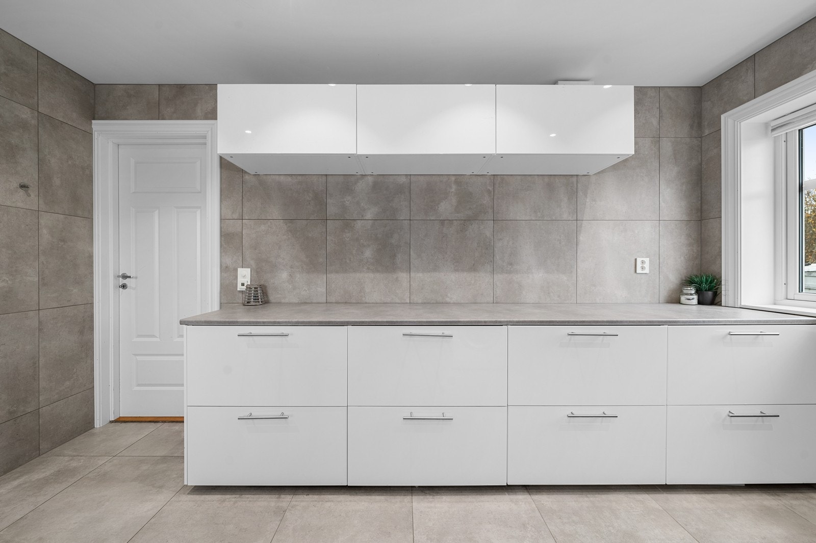 Vaskerommet har stor og praktisk benkeinnredning, vegghengt utslagsvask og opplegg for vaskemaskin Galleribilde