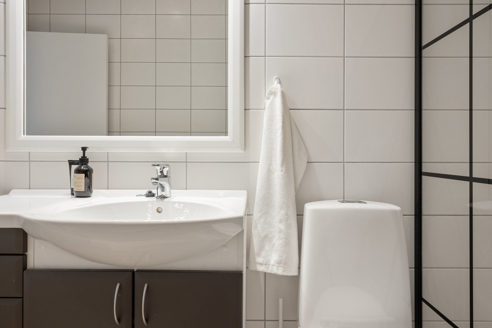 Badet måler ca. 5,4 kvm og er innredet med dusj m/glassvegger, toalett, opplegg for vaskemaskin og baderomsinnredning. Galleribilde