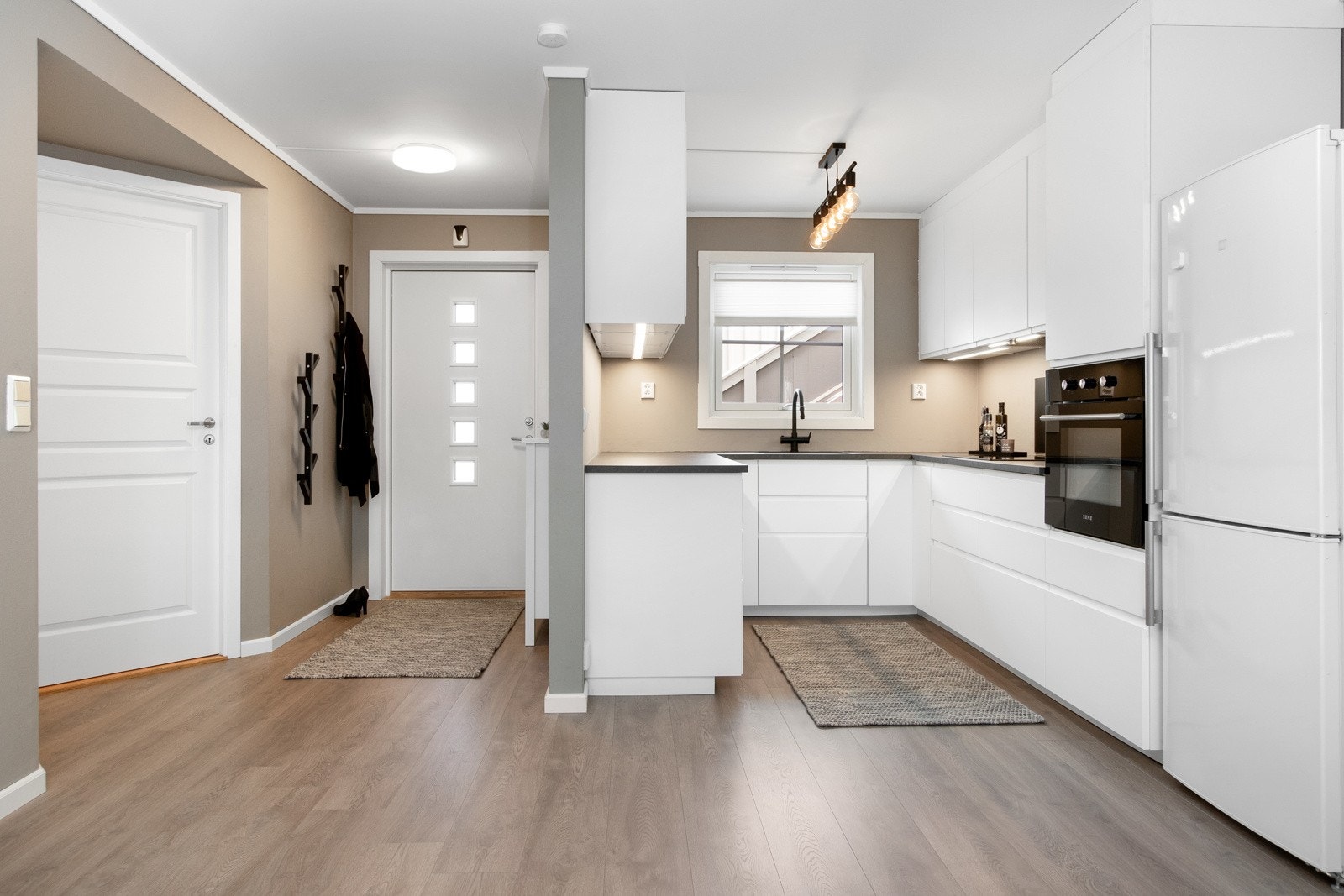 Kjøkkenet har en pen innredning i moderne stil, plassert i U-form - åpent mot stuen. Galleribilde