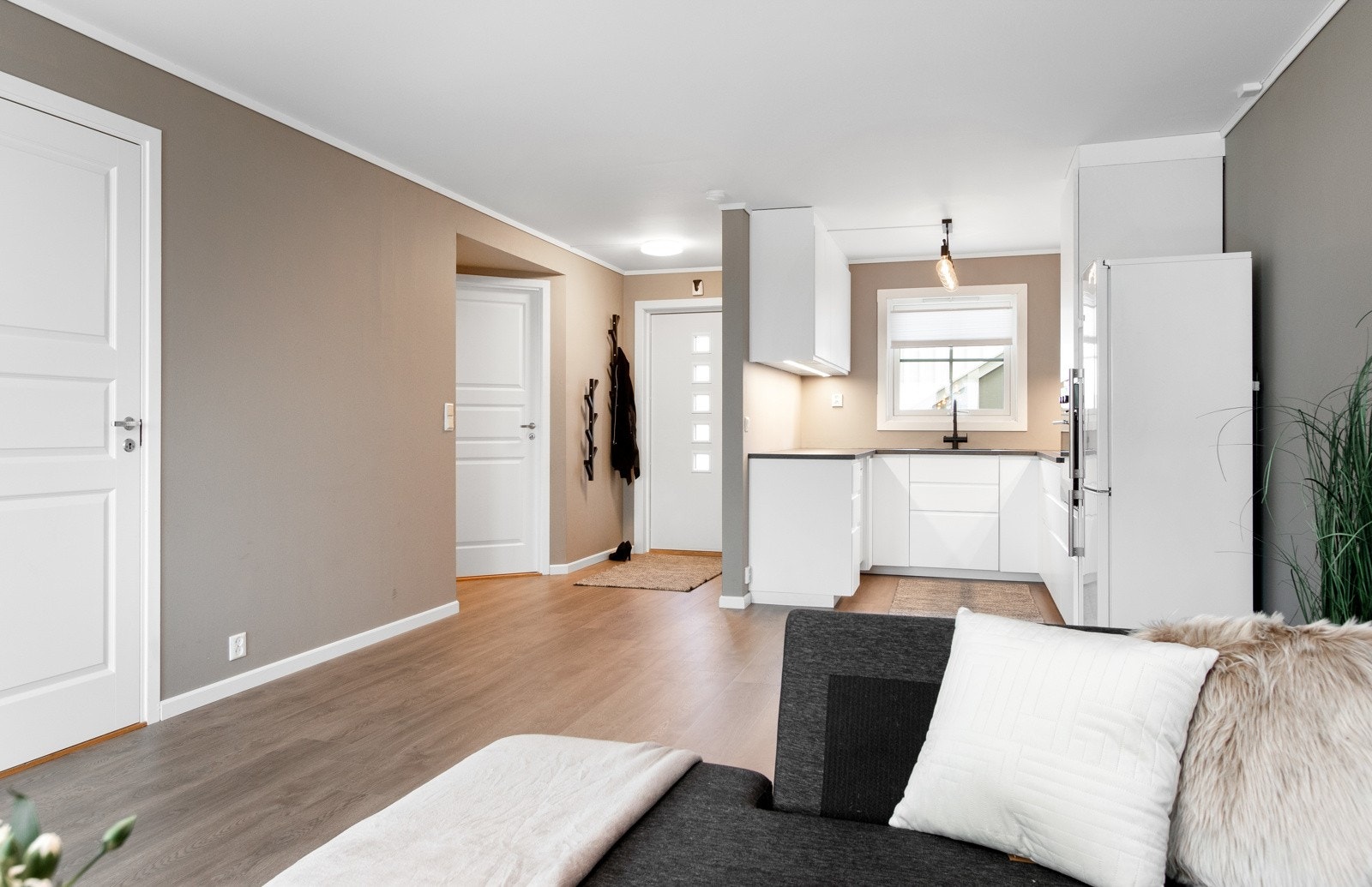 Leiligheten har glatte vegger malt i en trendy beigetone, enstavs laminat på gulvet og hvitmalt, glatt himling. Galleribilde