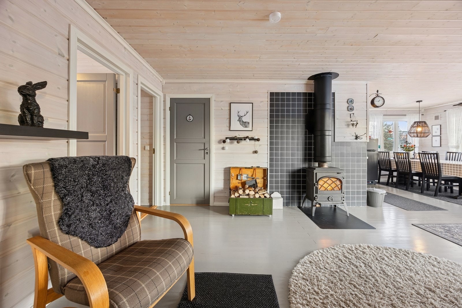 Stuen har furugulv og trepanel på vegger og tak. Galleribilde