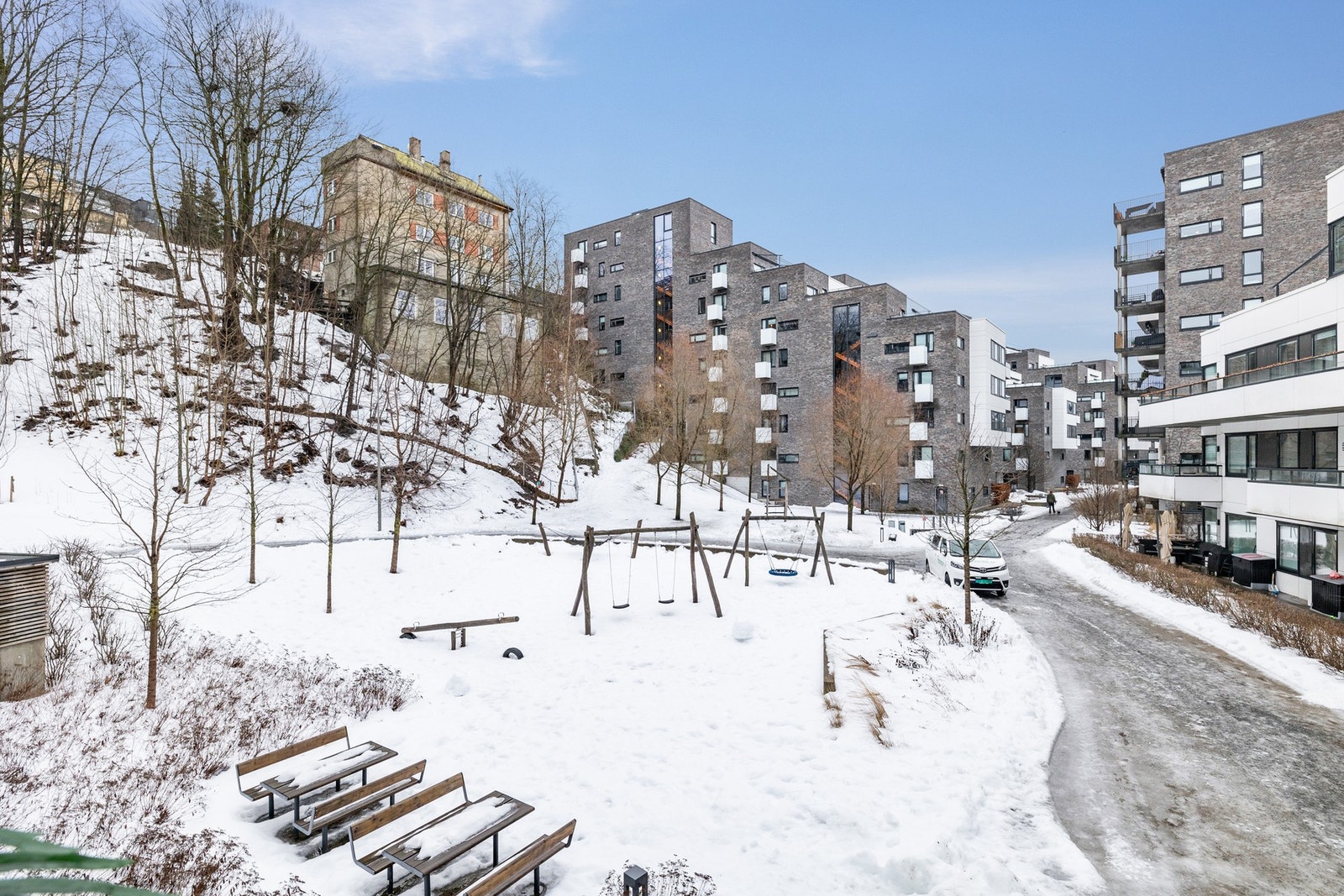 Området er pent opparbeidet med sittebenker og lekeplass Galleribilde