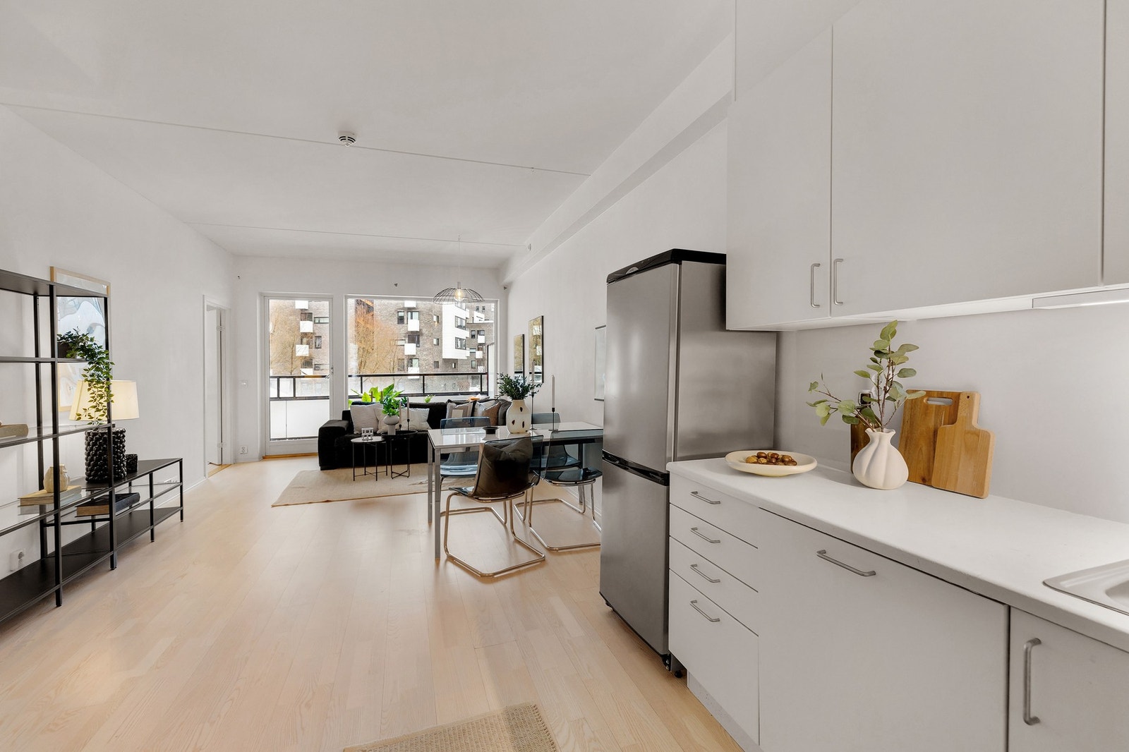 Lys og romslig stue med god plass til sofa med tilhørende møblement Galleribilde