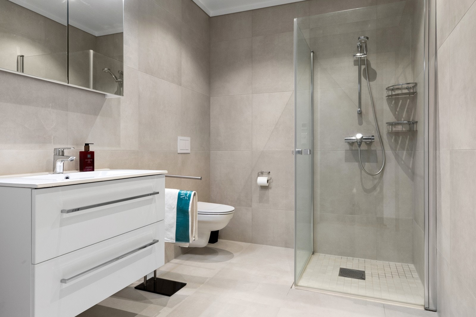 Baderommet i 1. etasje har store og tidsriktige fliser på gulv og vegger. Galleribilde