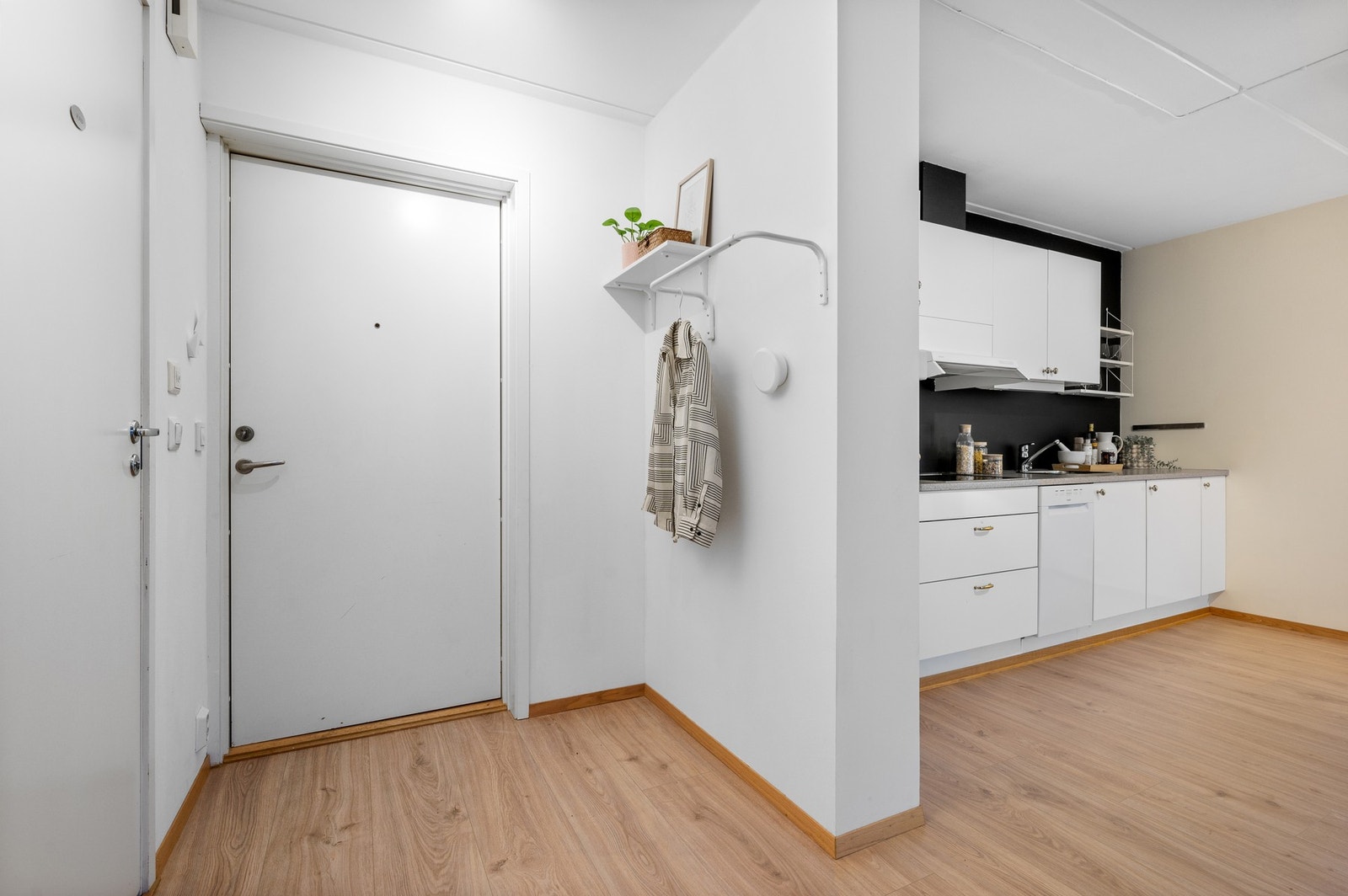 Entrè på ca. 4 kvadratmeter med vegghengte knagger for yttertøy. Galleribilde