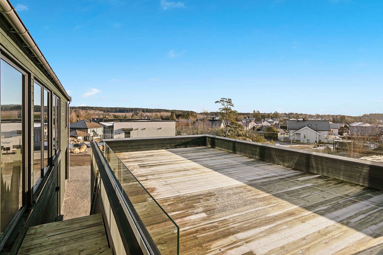 Det går trapp fra bakkeplan til 2 etasje mellom boligen og garasjen. Stor terrasse over garasjen med plass til sittegrupper Galleribilde