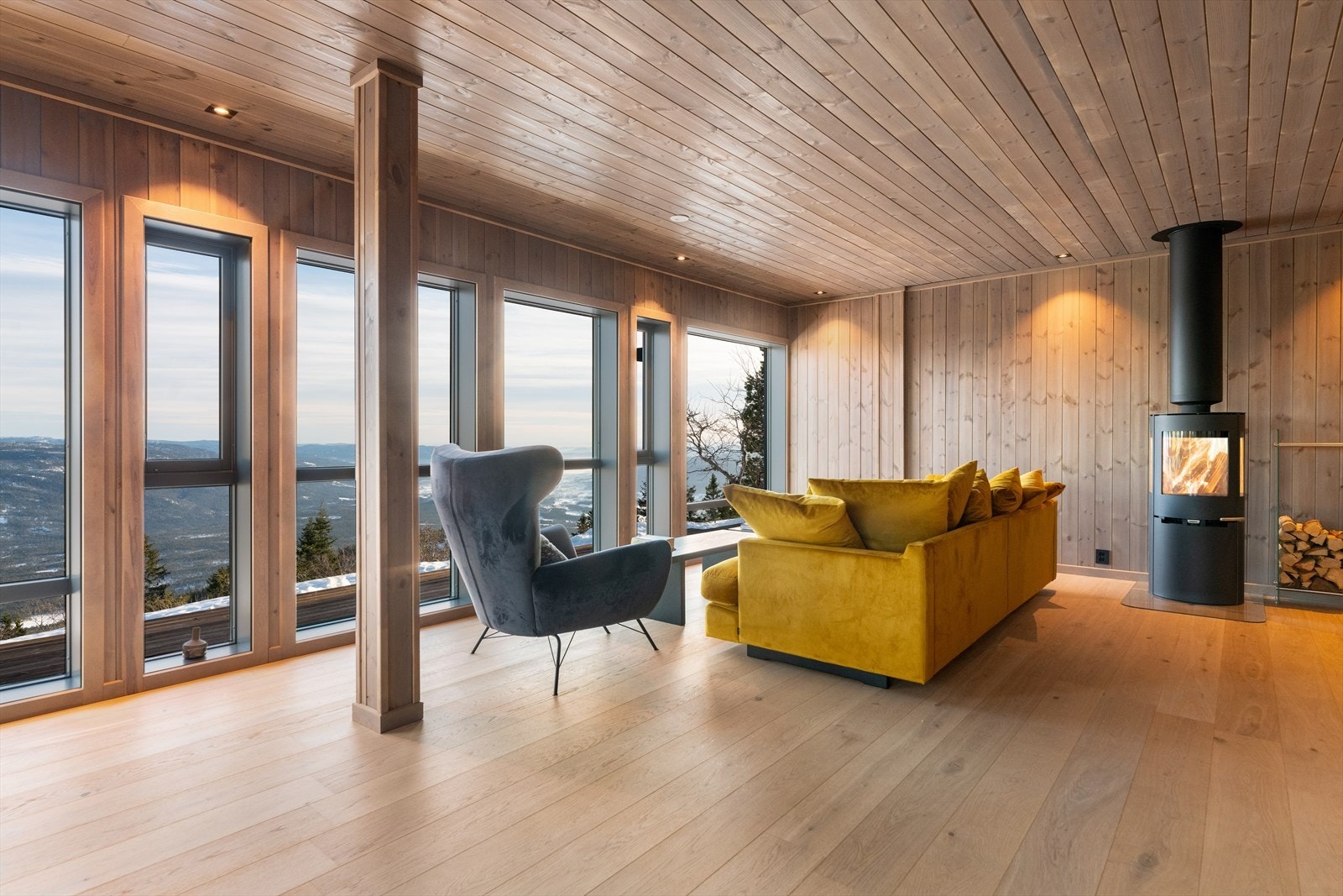 Hytta har en effektiv planløsning som gir fullt utbytte av de 91 kvadratmeterne, samtidig som den gir skjermede oppholdssoner. I stuen er det montert en flott vedovn for lun varme på kaldere dager. Galleribilde