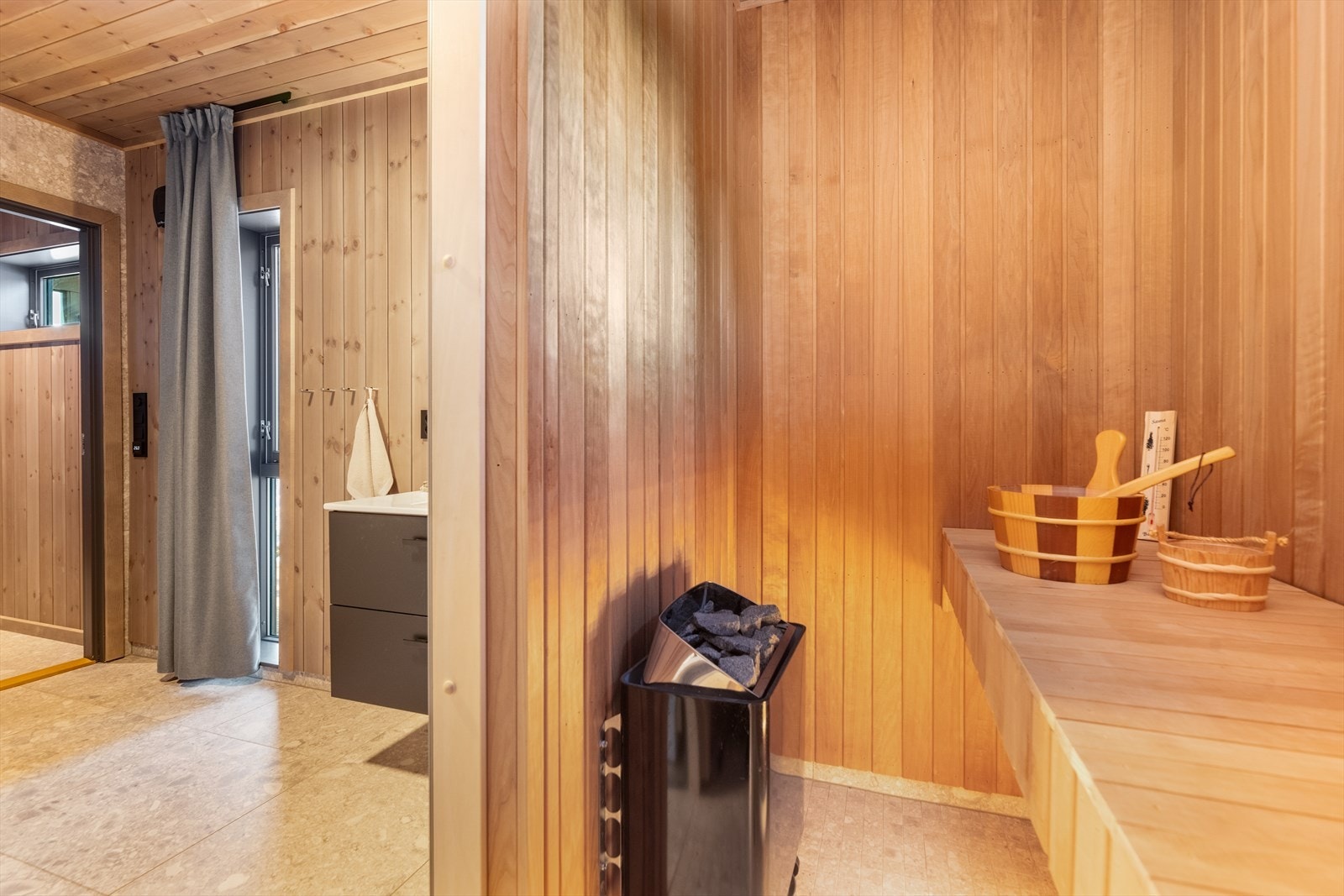 Badet har flis på gulv med gulvvarme, flis og panel på vegger og panel i tak. Galleribilde