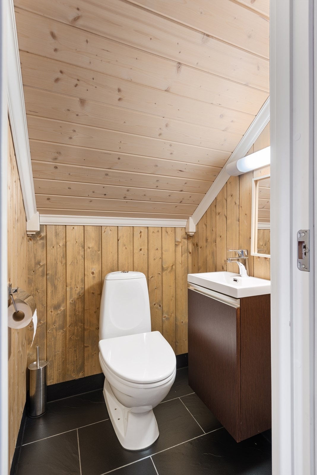 Opplev bekvemmeligheten av et eget toalett i hyttas andre etasje, komplett med servant og underskap. Ideelt for gjester eller familieboende på øvre nivå. Galleribilde