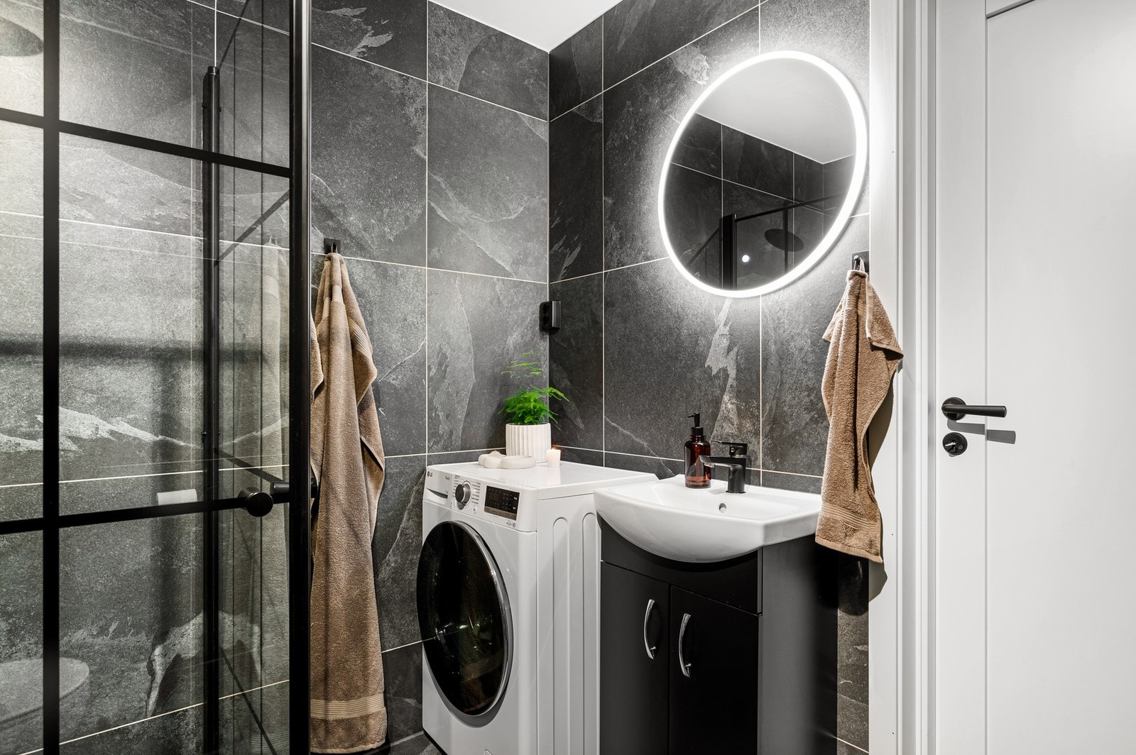 På badet finner du dusjhjørne, servant med underskap, toalett og opplegg for vaskemaskin. Galleribilde