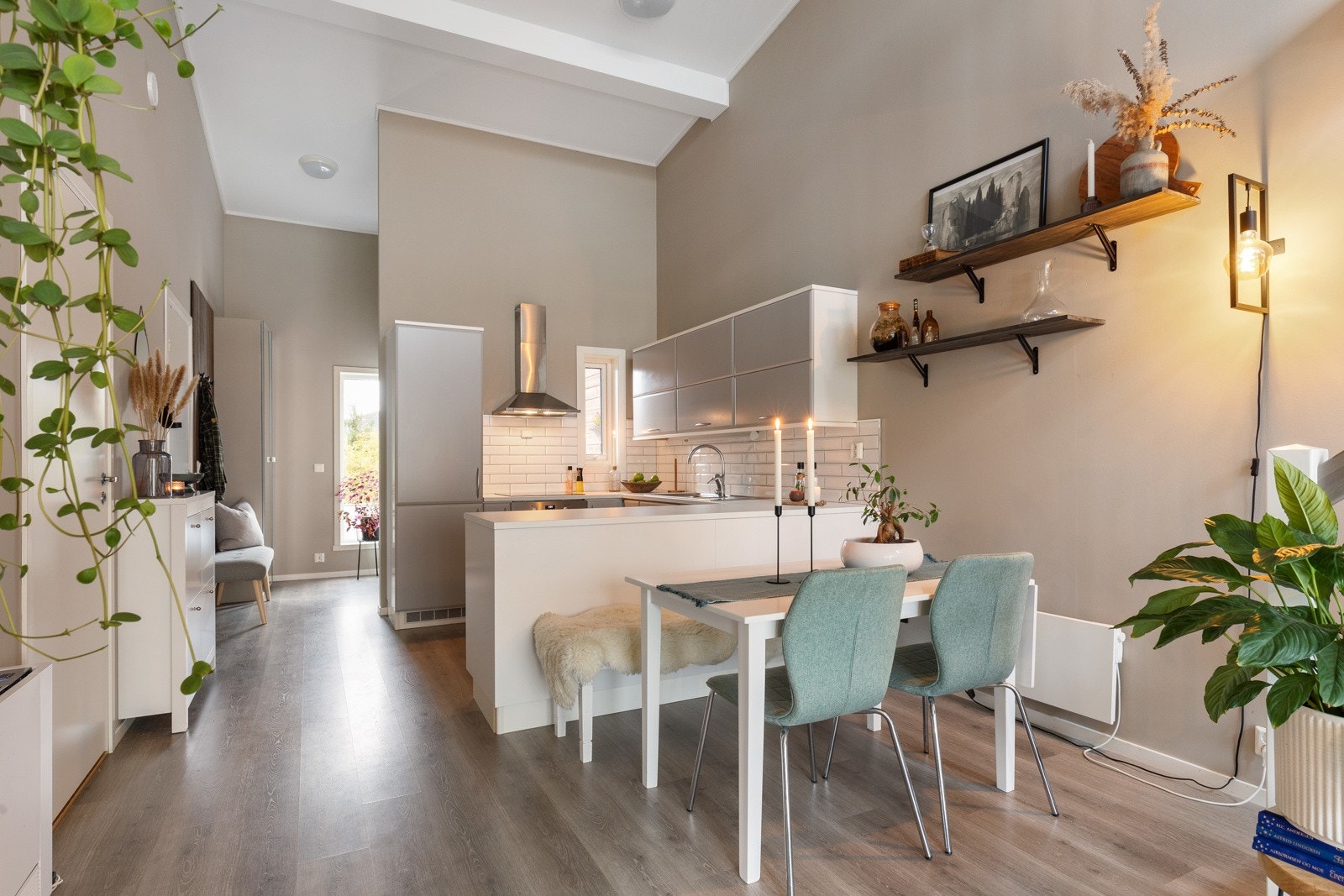 En åpen løsning mellom stue og kjøkken gir rom for sosiale soner selv ved matlaging Galleribilde