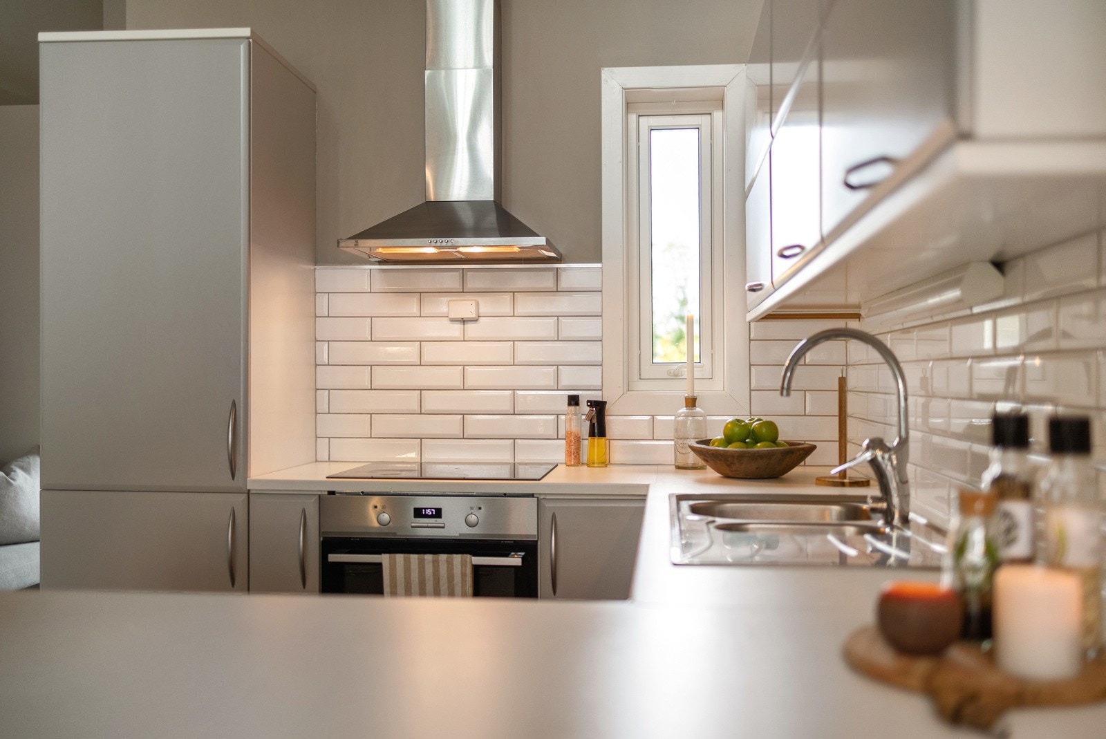 Kjøkkenet holder et tidløst preg med sine lyse fronter og integrerte hvitevarer Galleribilde