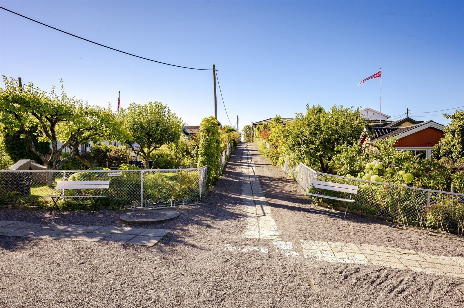 Frukttrærne, bugnende av epler, plommer og pærer, strekker grenene ut over de smale gangveiene og skaper en idyllisk atmosfære. Galleribilde