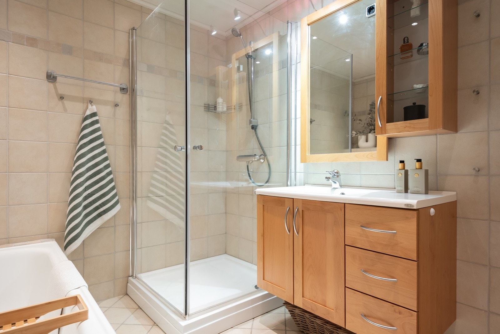 Badet er utstyrt med badekar, dusjkabinett, toalett og servant med romslig innredning. Galleribilde