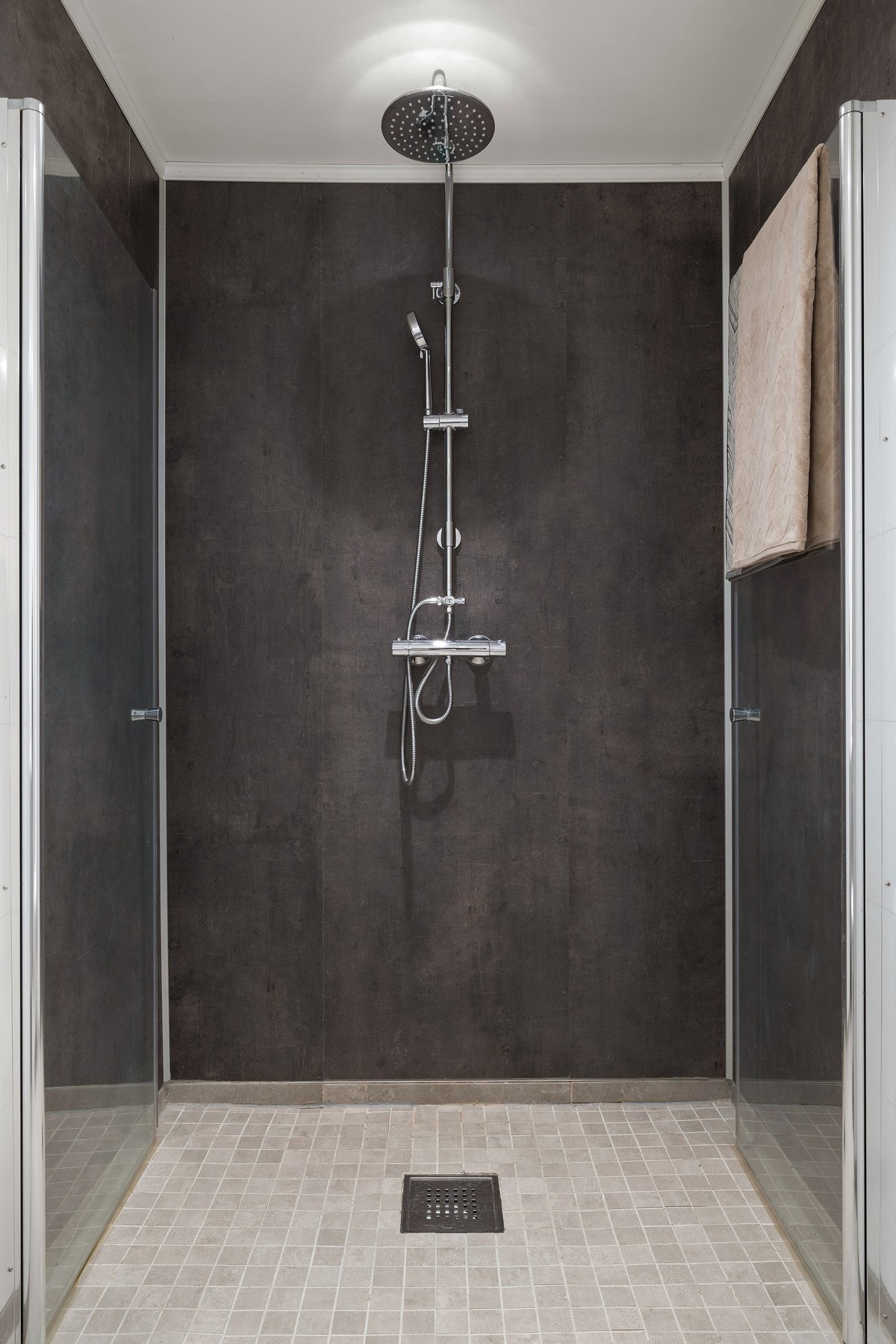 Dusjnisjen har doble, innfellbare dusjdører i glass og en behagelig tropedusj. Galleribilde