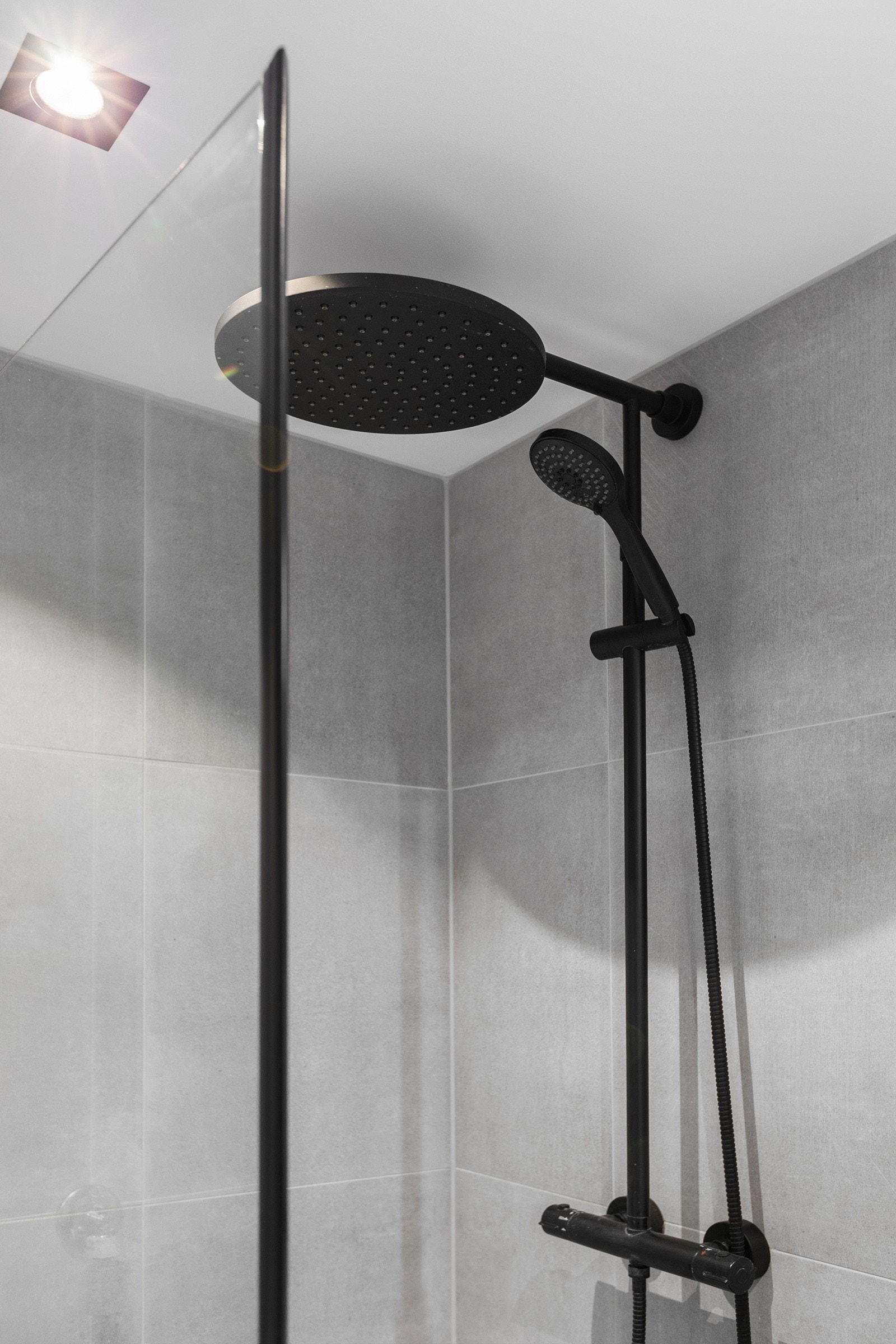 Sorte detaljer på dusjdører. Topp- og hånddusj. Galleribilde