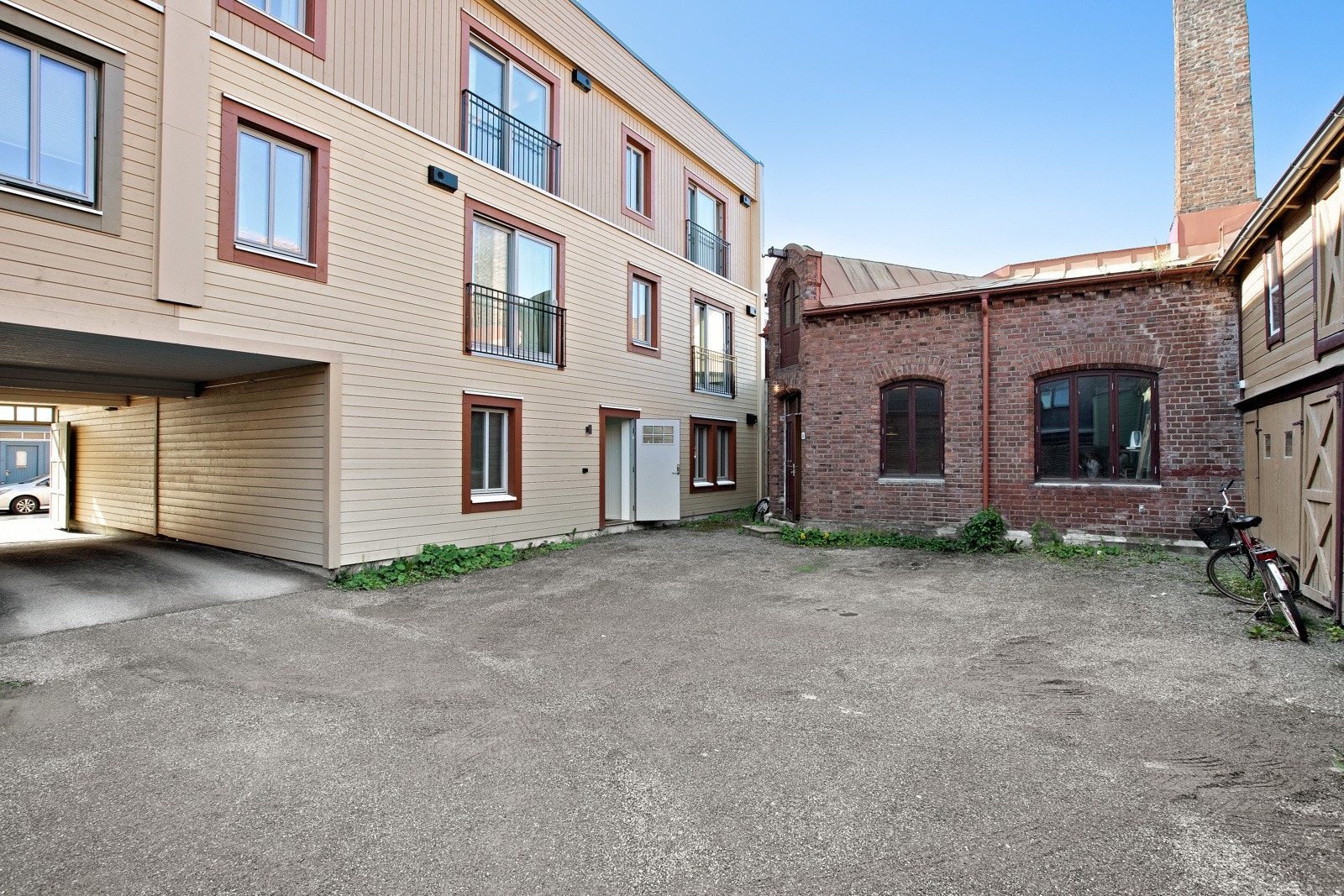 Bakgård med bodrekke til høyre. Leiligheten disponerer 1 bod i rekken. Inngang til leiligheten også fra bakgård. Galleribilde