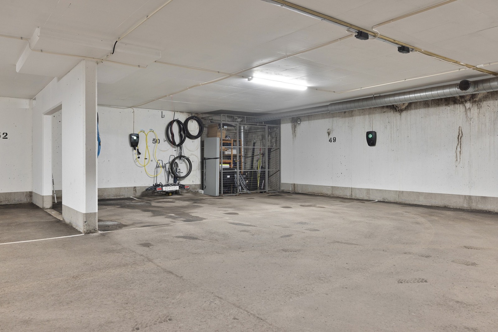 Leiligheten disponerer en garasjeplass med elbillader, samt en tilhørende gitterbod i bakkant. Galleribilde