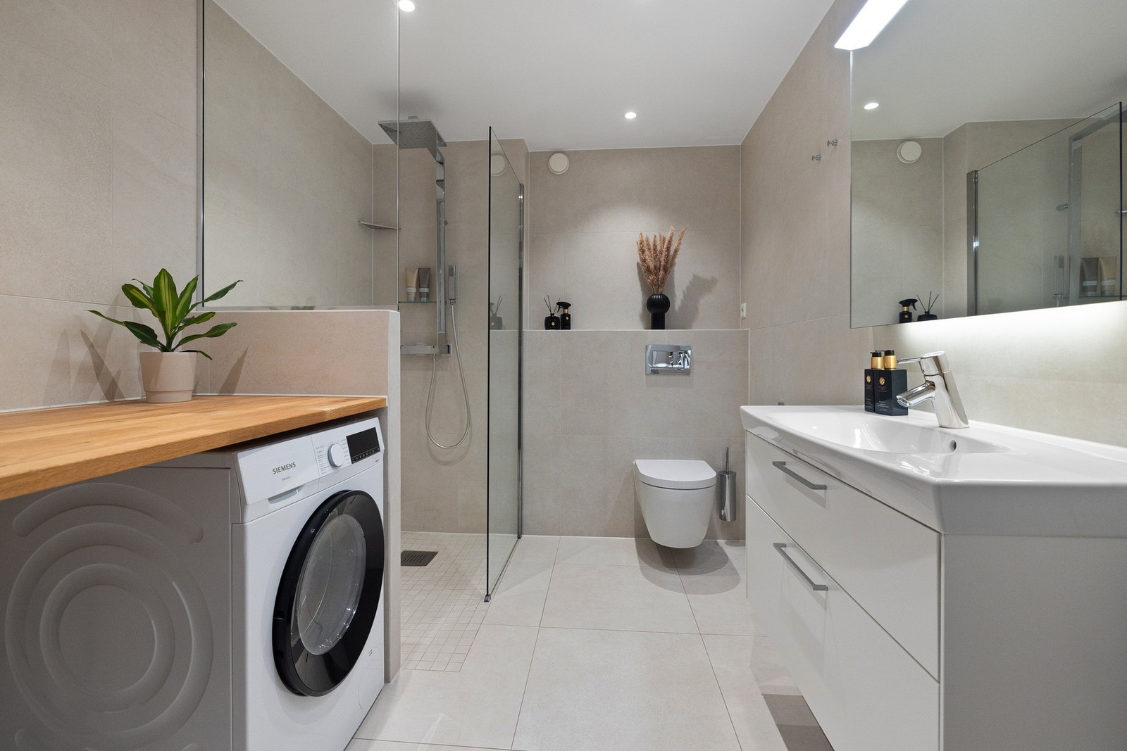 Badet fremstår som stilrent og moderne, med bl.a. tilpasset benkeplate over opplegg for vaskemaskin og tørketrommel. Galleribilde