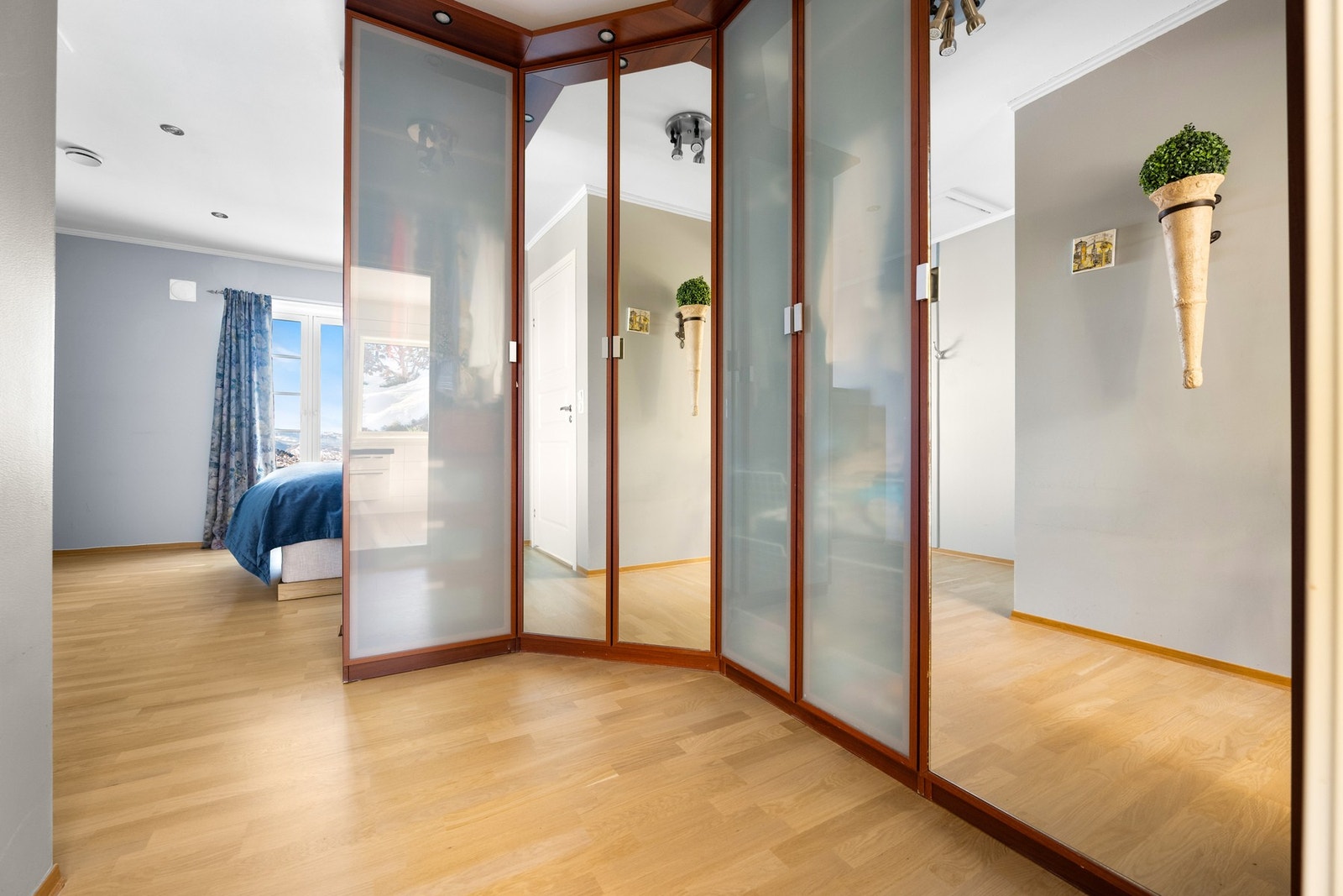 Tilstøtende garderoberom i sonen mellom soverommet og badet. Garderobedelen har godt utstyrt skapløsning med speilfronter og belysning. Galleribilde