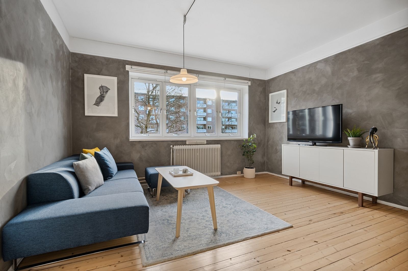 Romslig stue med god plass til sofa og tv-benk med oppbevaring. Stort vindu som byr på masse dagslys Galleribilde