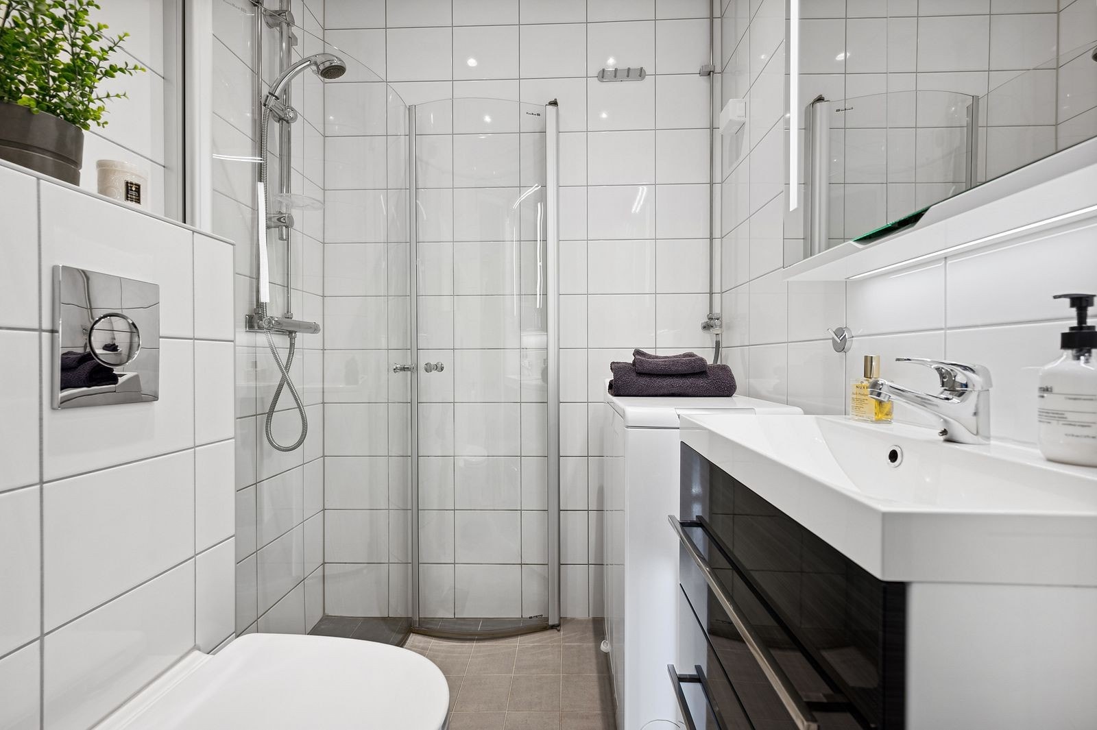 Moderne flisbelagt bad med tilhørende vaskemaskin Galleribilde